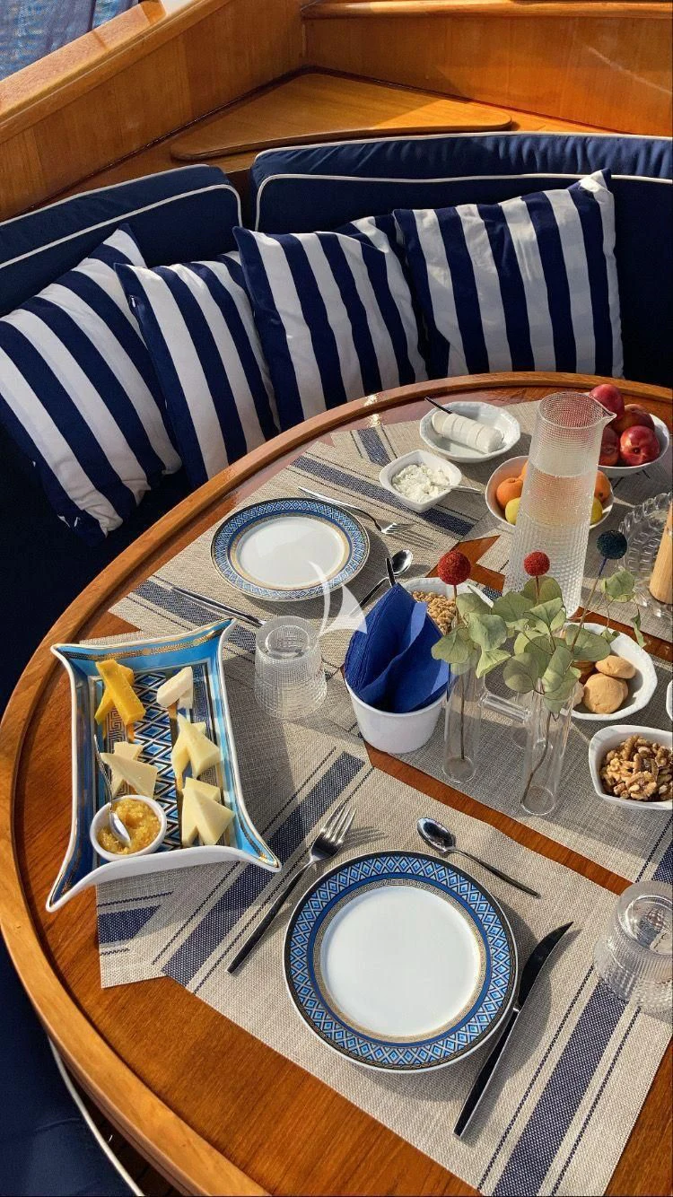 a table with plates and glasses on it aboard MALIZIA Yacht for Sale