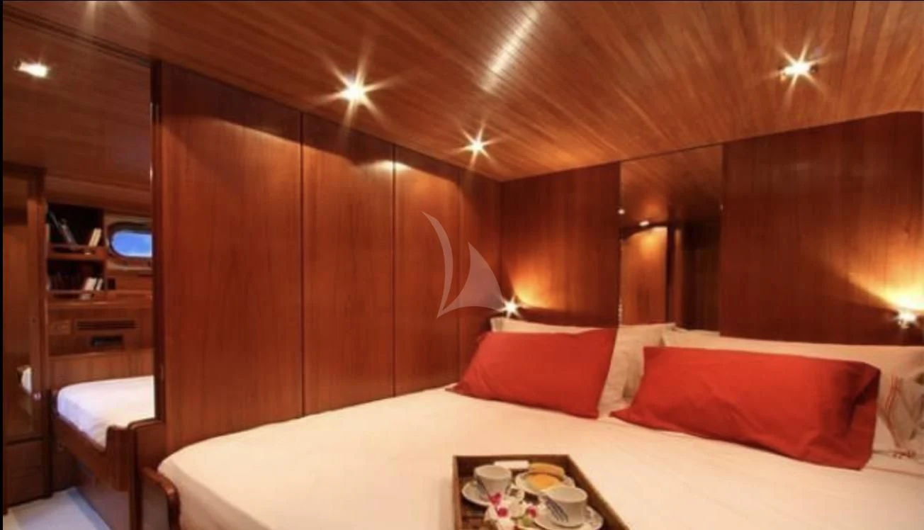 a bed with a white bed spread aboard MALIZIA Yacht for Sale