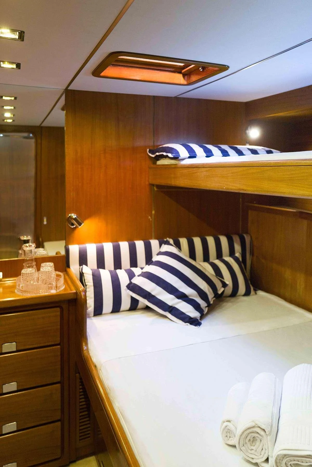a bed with white and blue striped pillows aboard MALIZIA Yacht for Sale