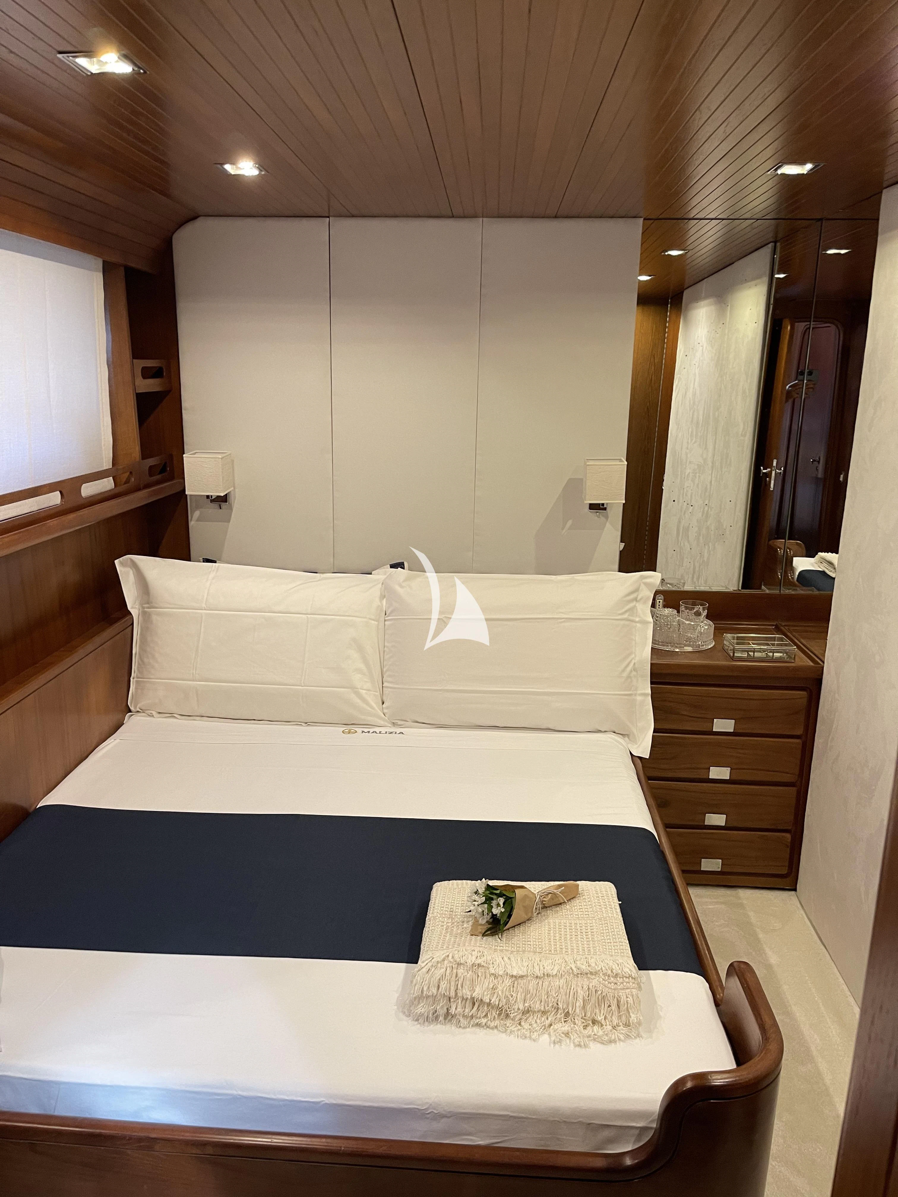 a bed with white sheets aboard MALIZIA Yacht for Sale