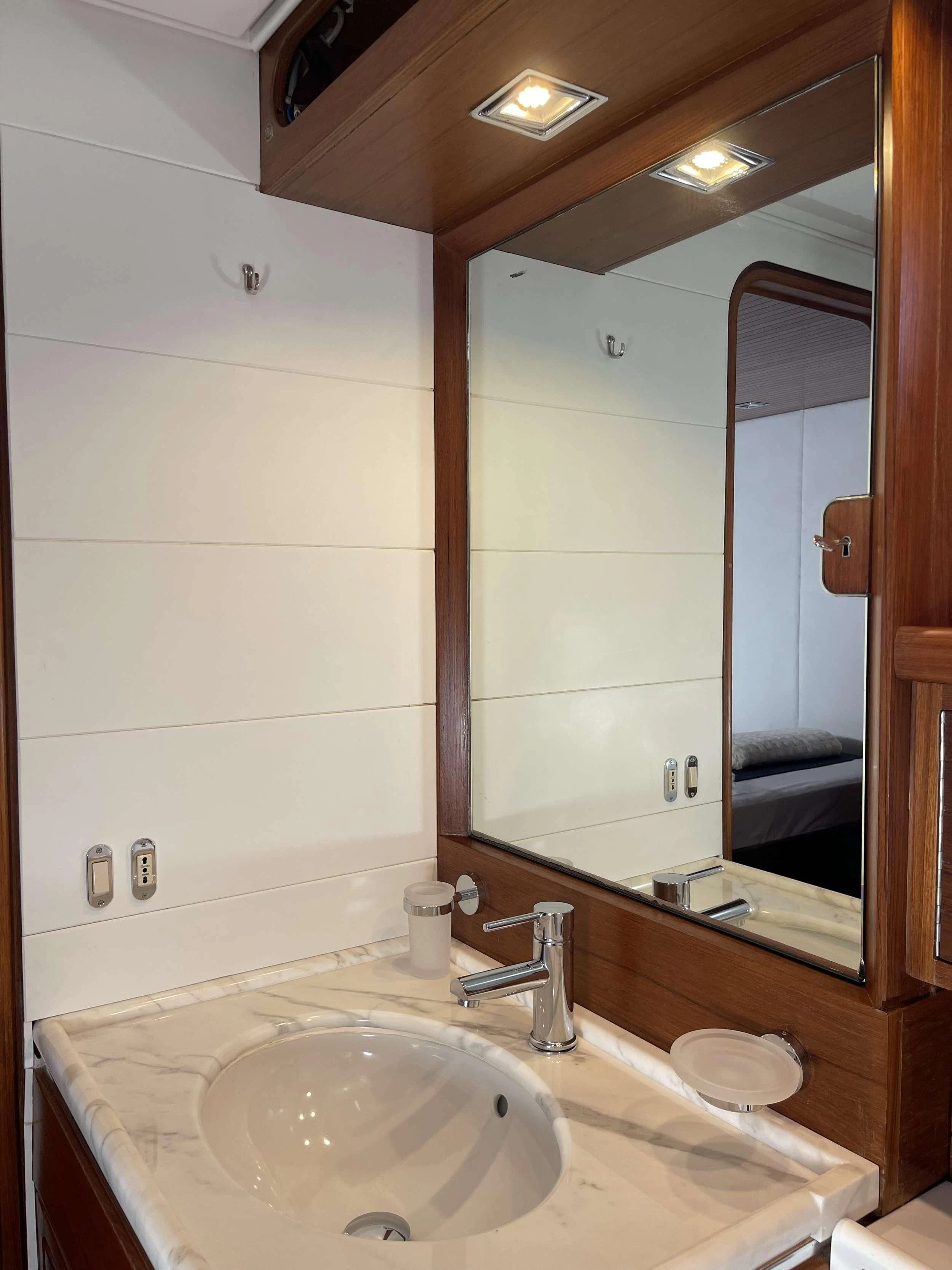 a bathroom with a sink and mirror aboard MALIZIA Yacht for Sale
