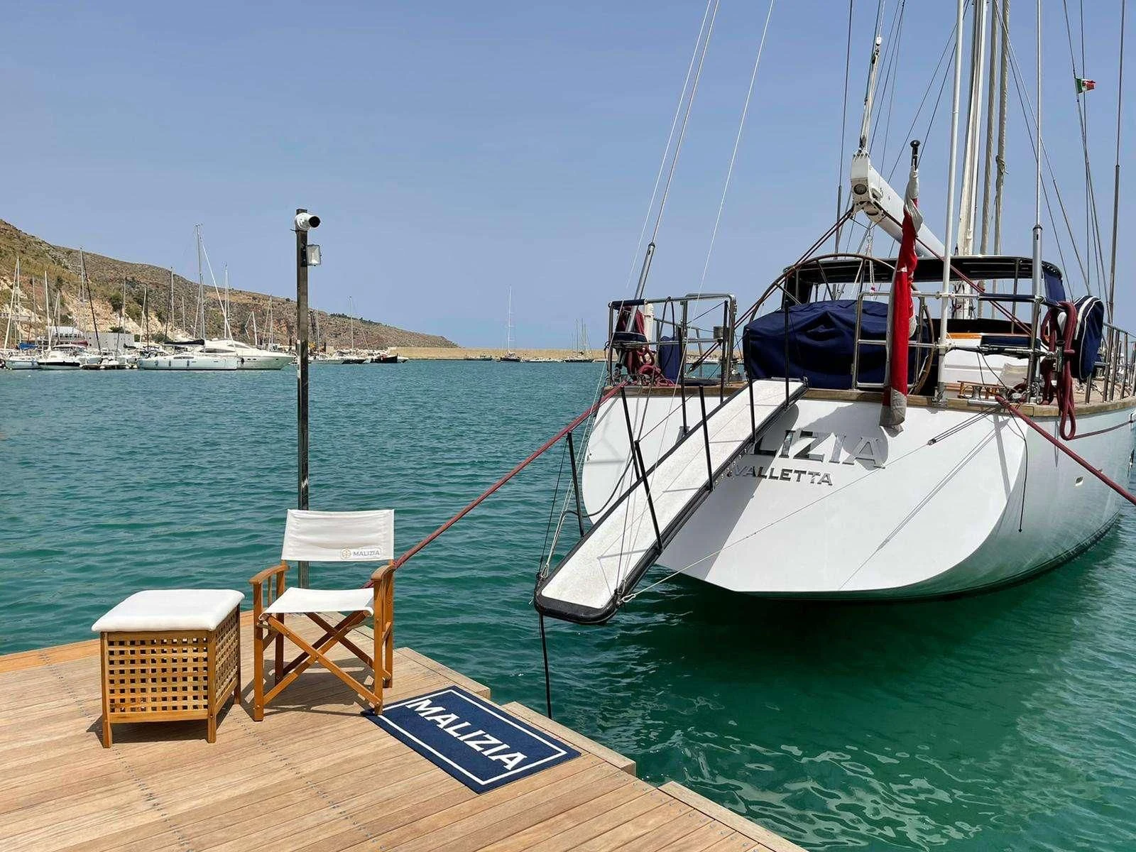 a boat tied to a dock aboard MALIZIA Yacht for Sale