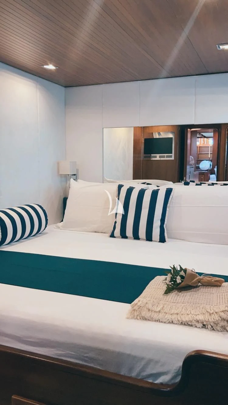 a bed with blue and white sheets aboard MALIZIA Yacht for Sale