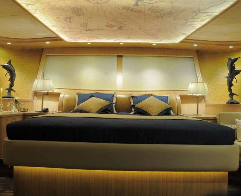 a bed with a black bed spread aboard BLUE HEAVEN Yacht for Charter