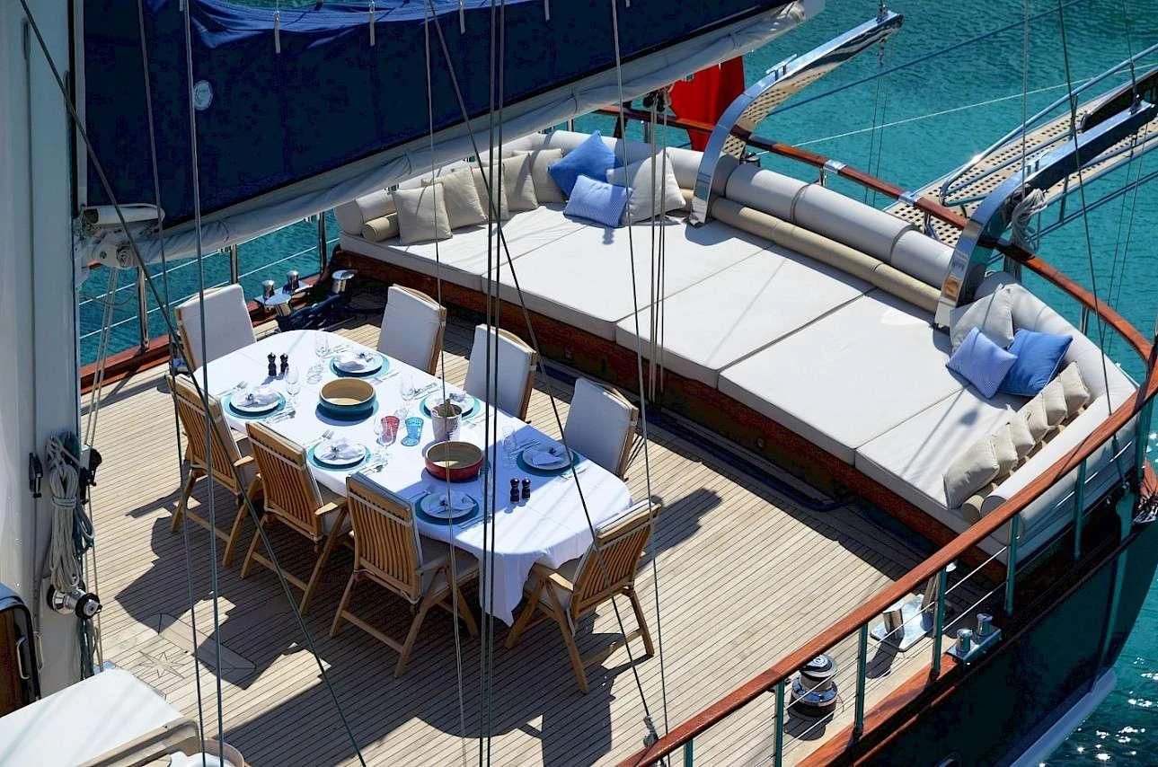 a large boat with a table and chairs aboard BLUE HEAVEN Yacht for Charter