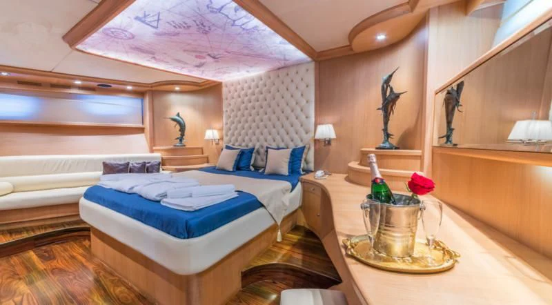 a room with a bed and a table aboard BLUE HEAVEN Yacht for Charter