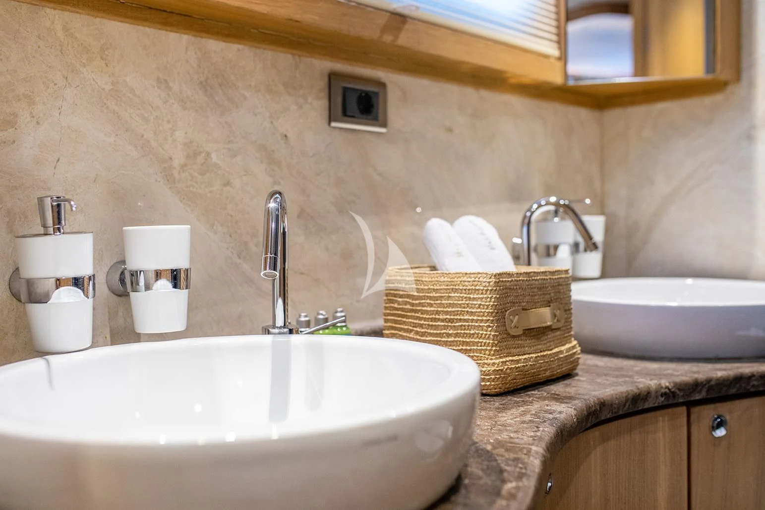 a bathroom with a sink and a basket aboard BLUE HEAVEN Yacht for Charter