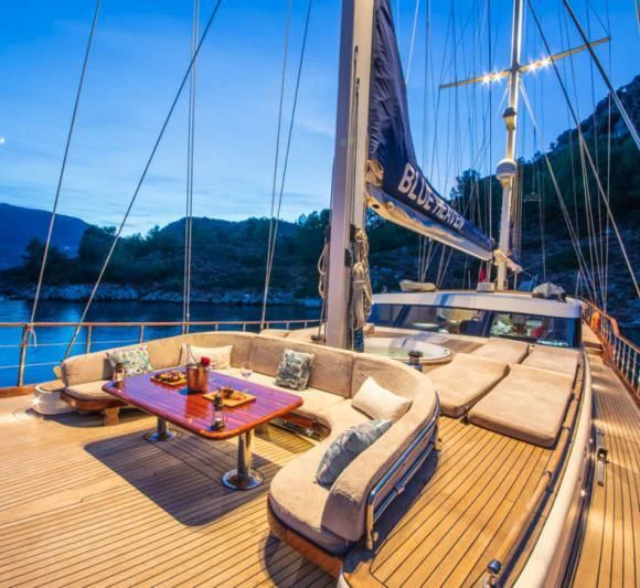 a deck with a table and chairs on it aboard BLUE HEAVEN Yacht for Charter