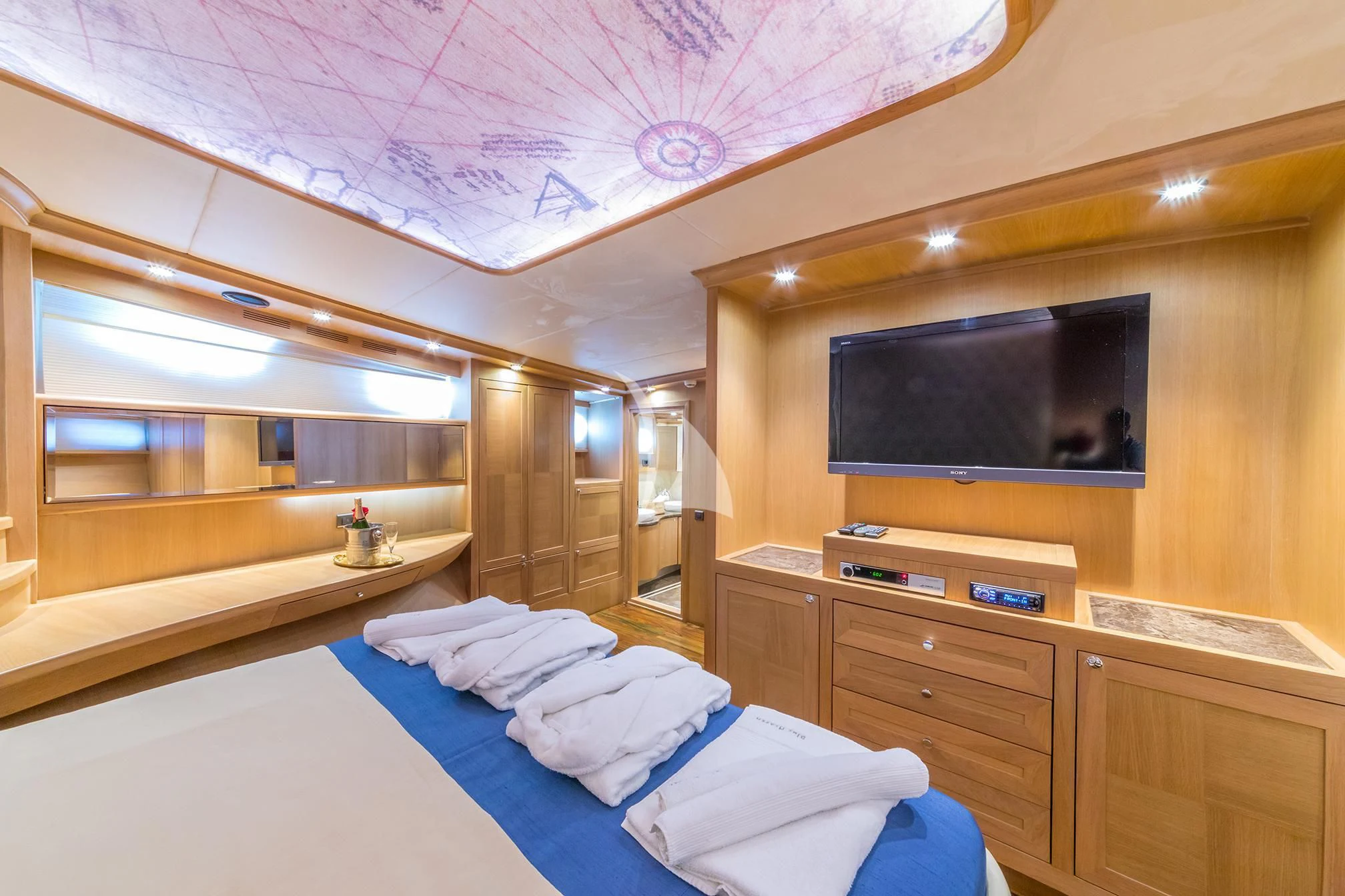 a room with a bed and a television aboard BLUE HEAVEN Yacht for Charter