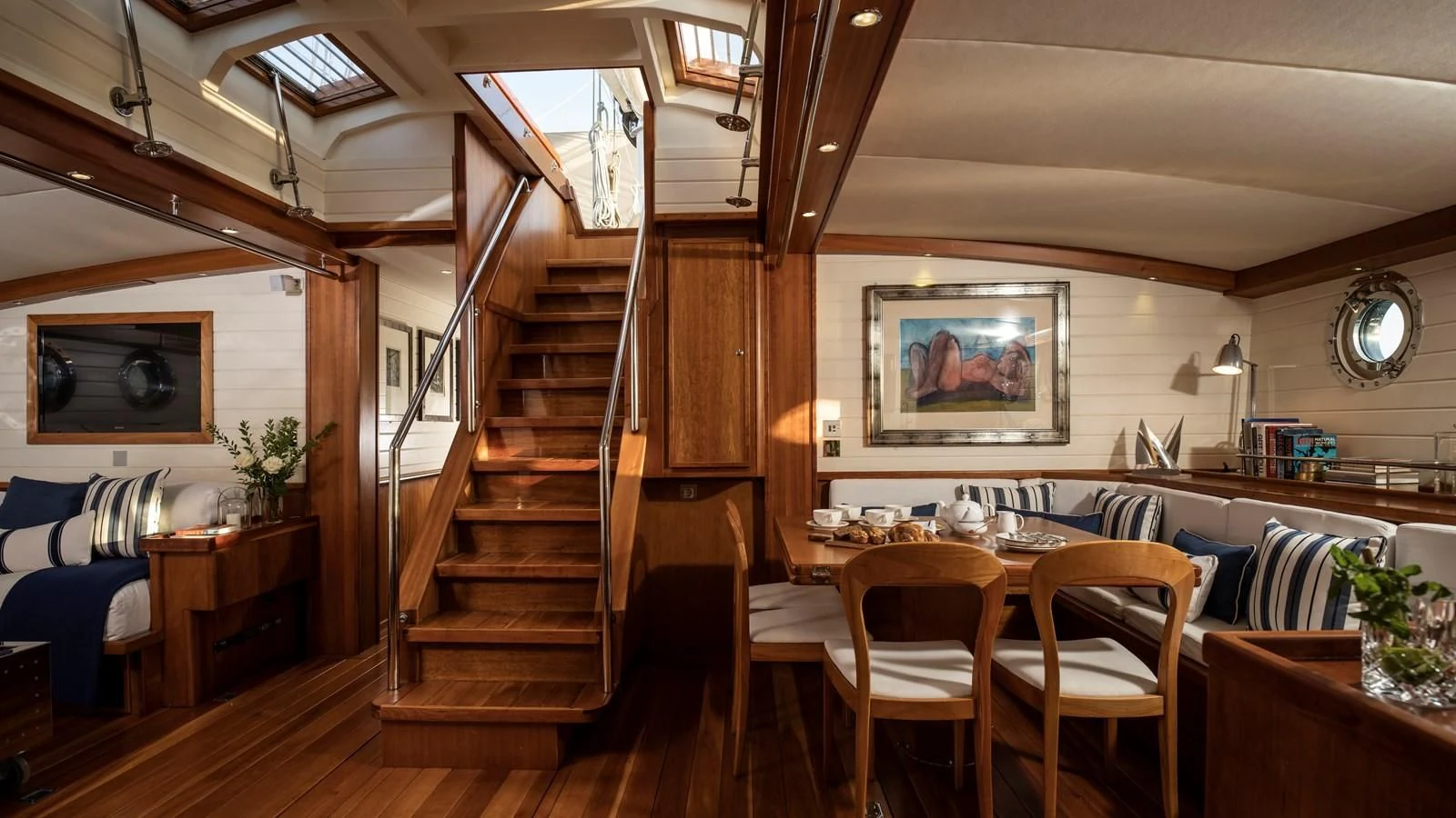 a room with a staircase and a table and chairs aboard ALEXA OF LONDON Yacht for Sale