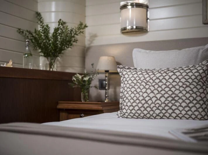 a bed with a white pillow and a plant on the side aboard ALEXA OF LONDON Yacht for Sale