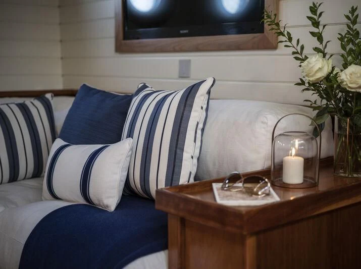 a couch with a table and a vase with flowers on it aboard ALEXA OF LONDON Yacht for Sale