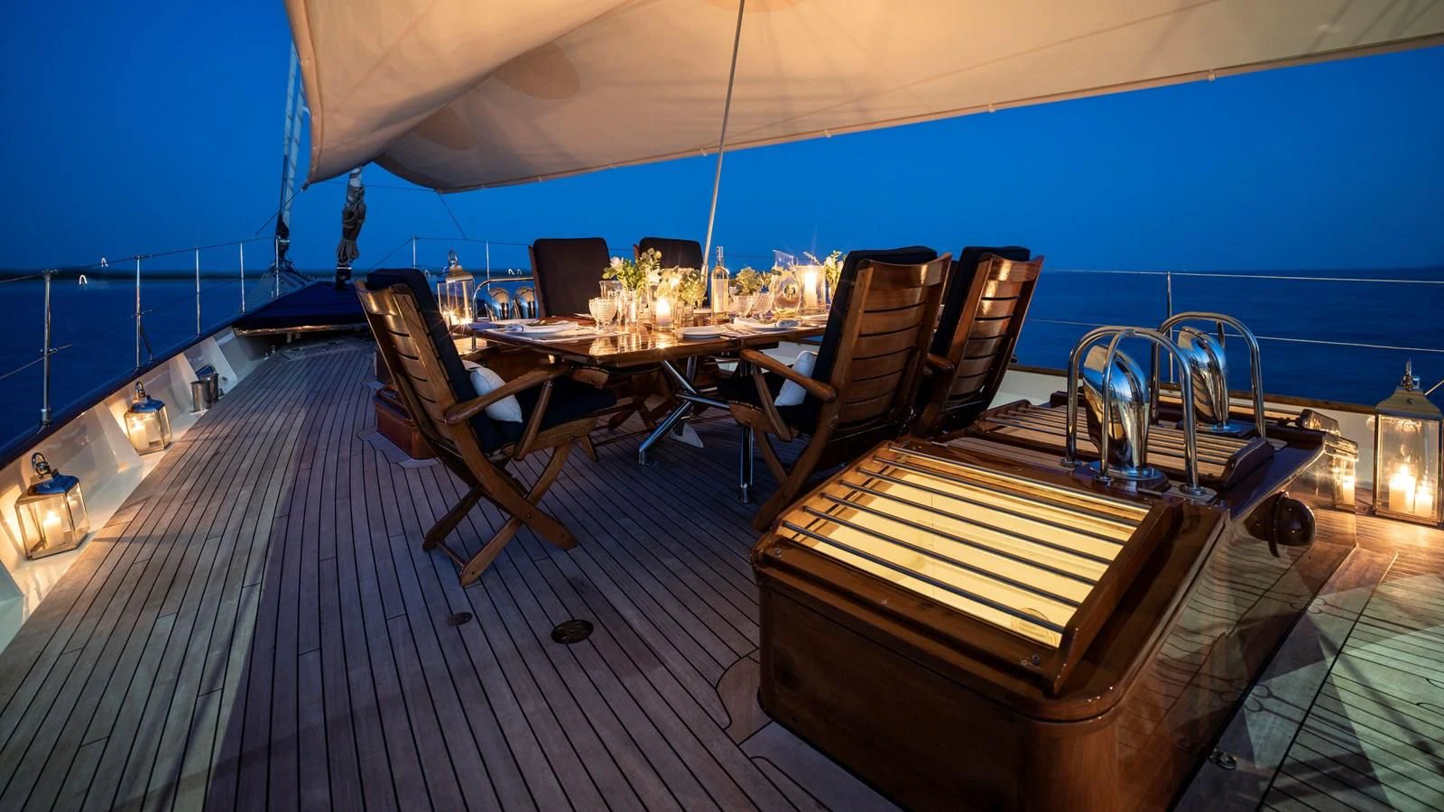 a deck with a table and chairs on it aboard ALEXA OF LONDON Yacht for Sale