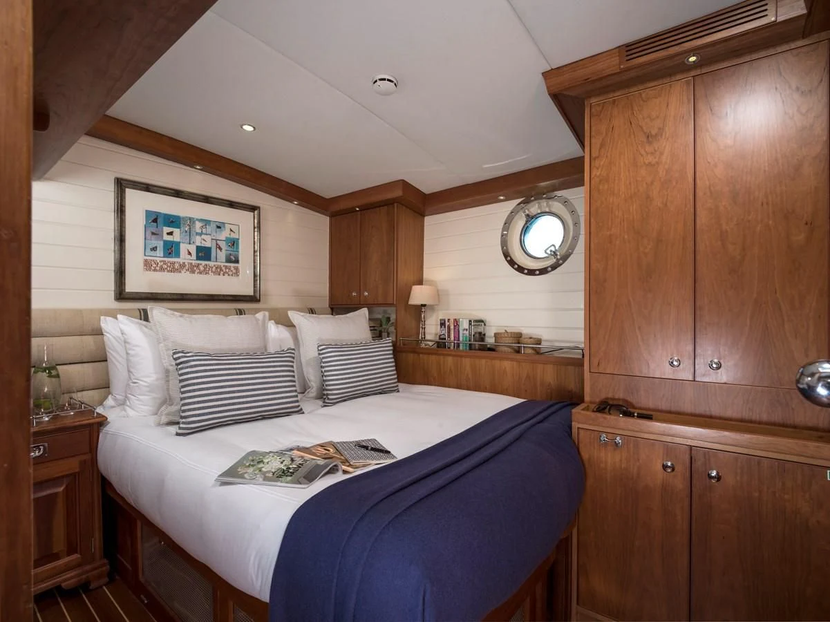 a bedroom with a bed and a dresser aboard ALEXA OF LONDON Yacht for Sale