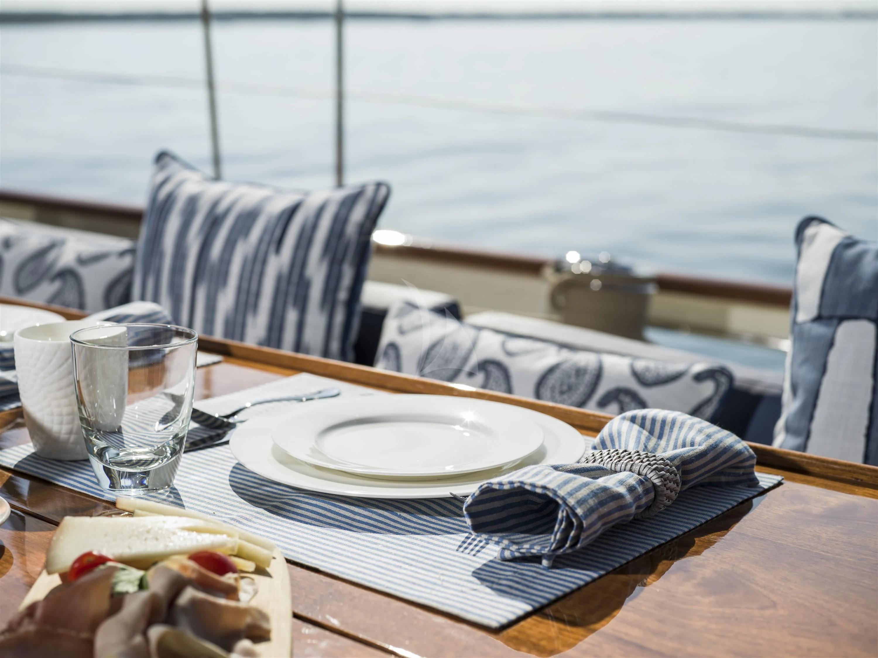 a table with a plate of food and a glass of water aboard ALEXA OF LONDON Yacht for Sale