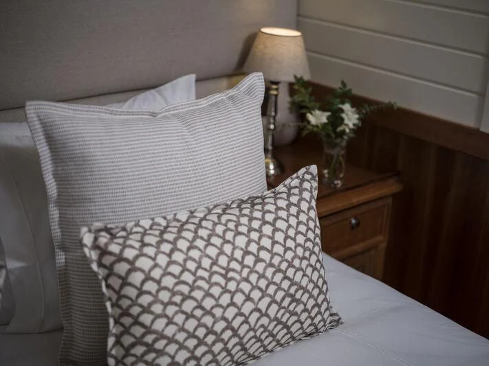 a bed with white sheets and pillows aboard ALEXA OF LONDON Yacht for Sale