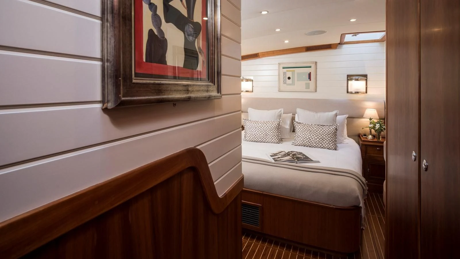 a room with a bed and a painting on the wall aboard ALEXA OF LONDON Yacht for Sale
