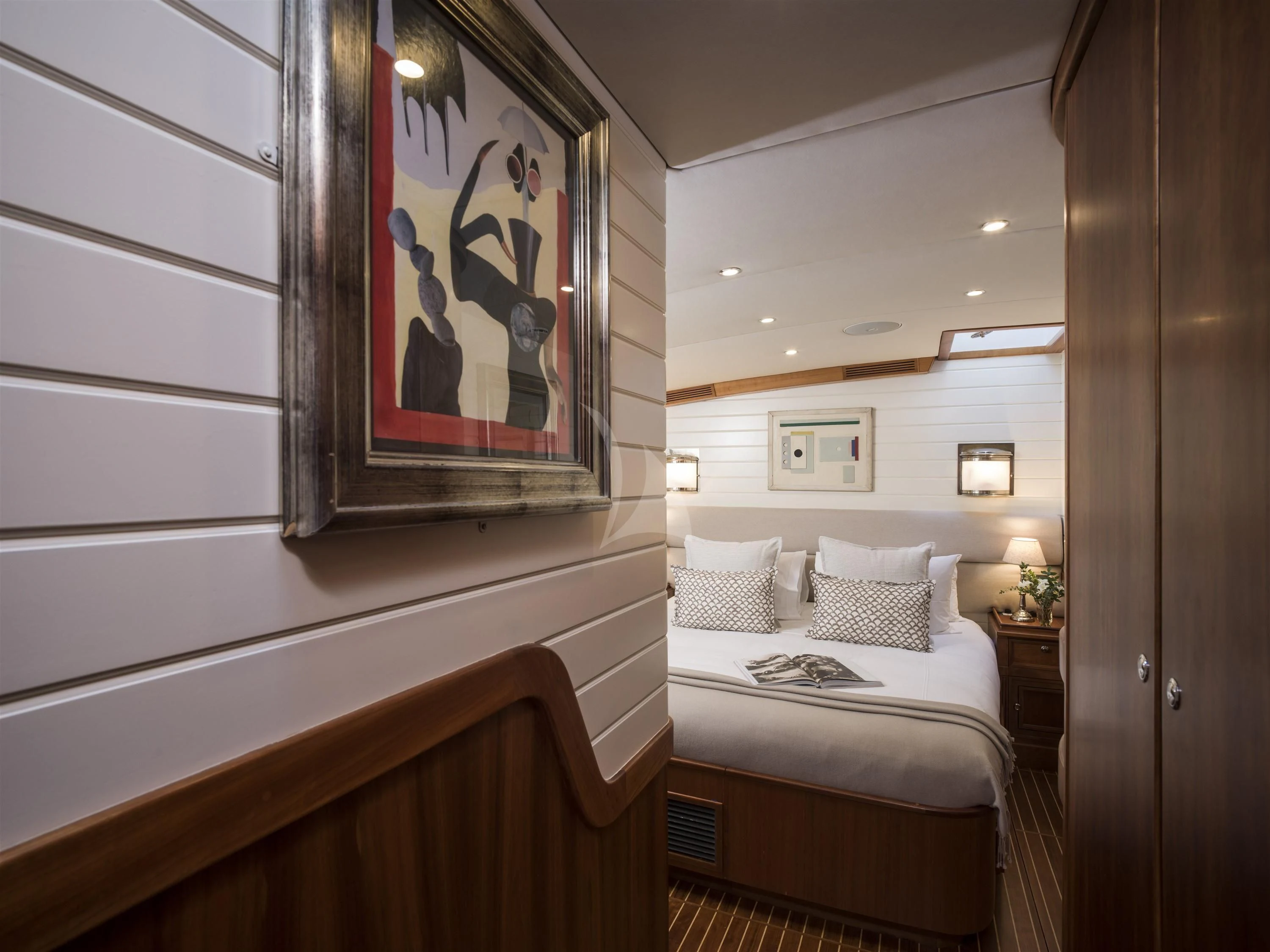 a bedroom with a painting on the wall aboard ALEXA OF LONDON Yacht for Sale