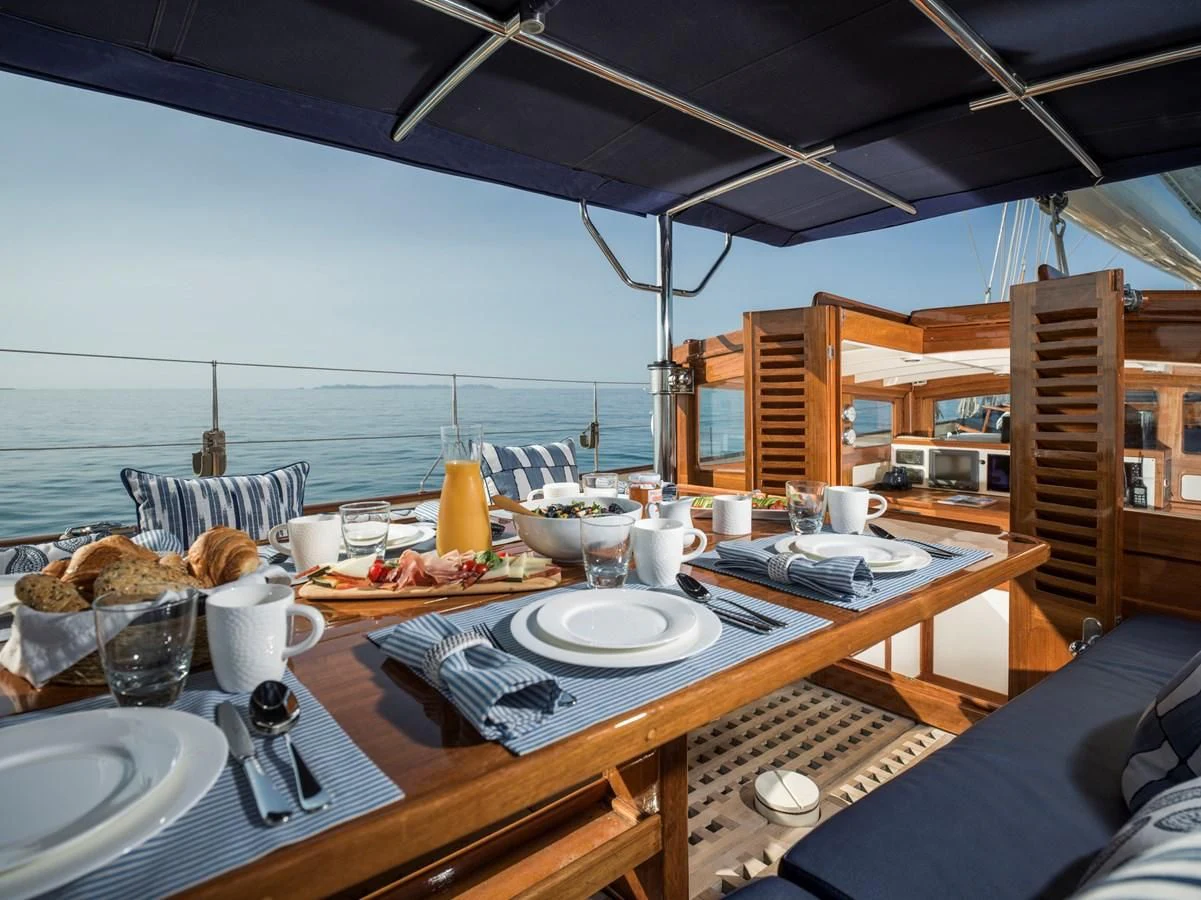 a table with plates and food on it aboard ALEXA OF LONDON Yacht for Sale