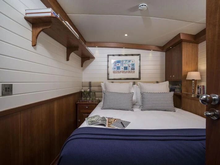 a bedroom with a bed and a wood wall aboard ALEXA OF LONDON Yacht for Sale
