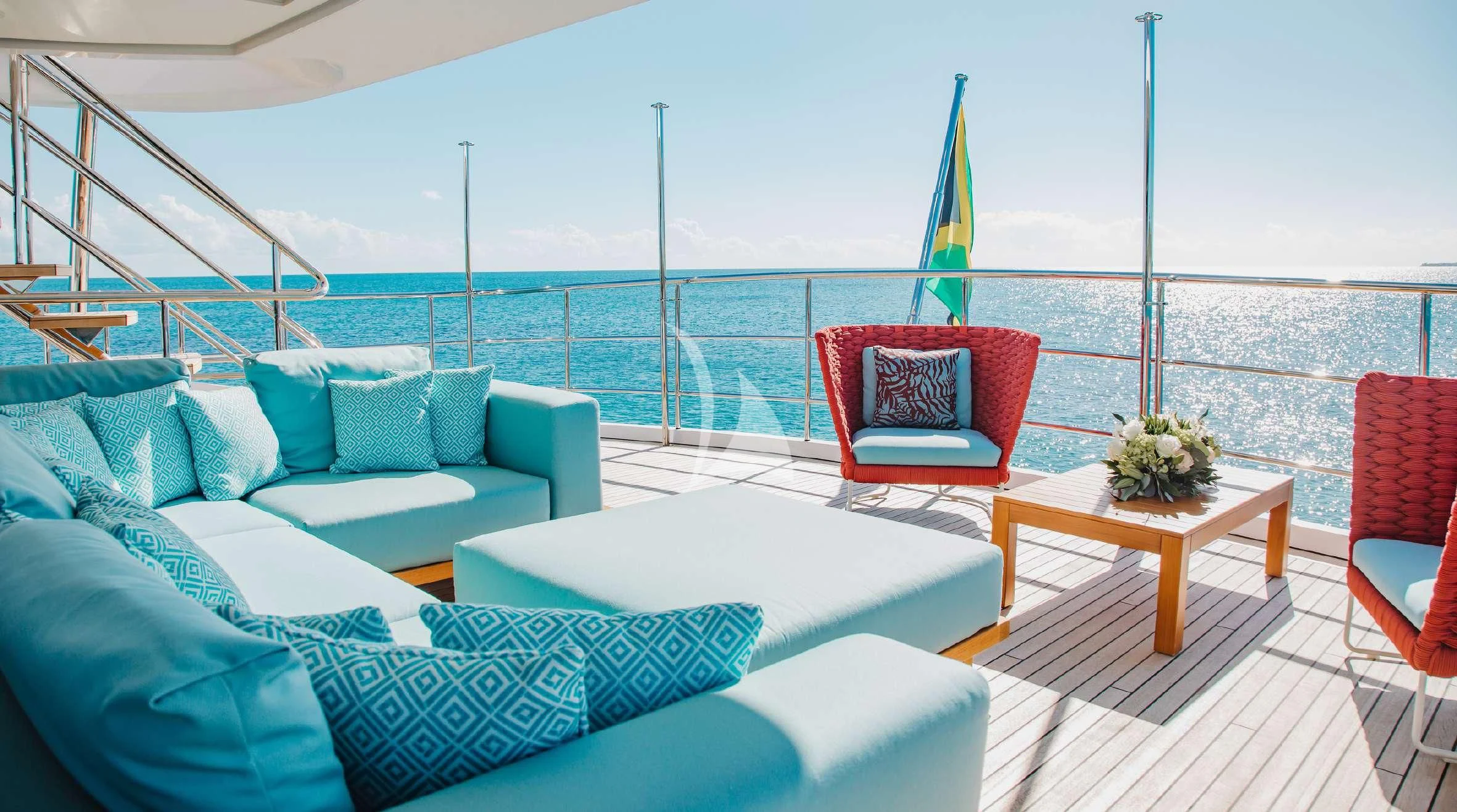 a deck with a large body of water and a couch with a chair and a table with a aboard COFINA Yacht for Sale
