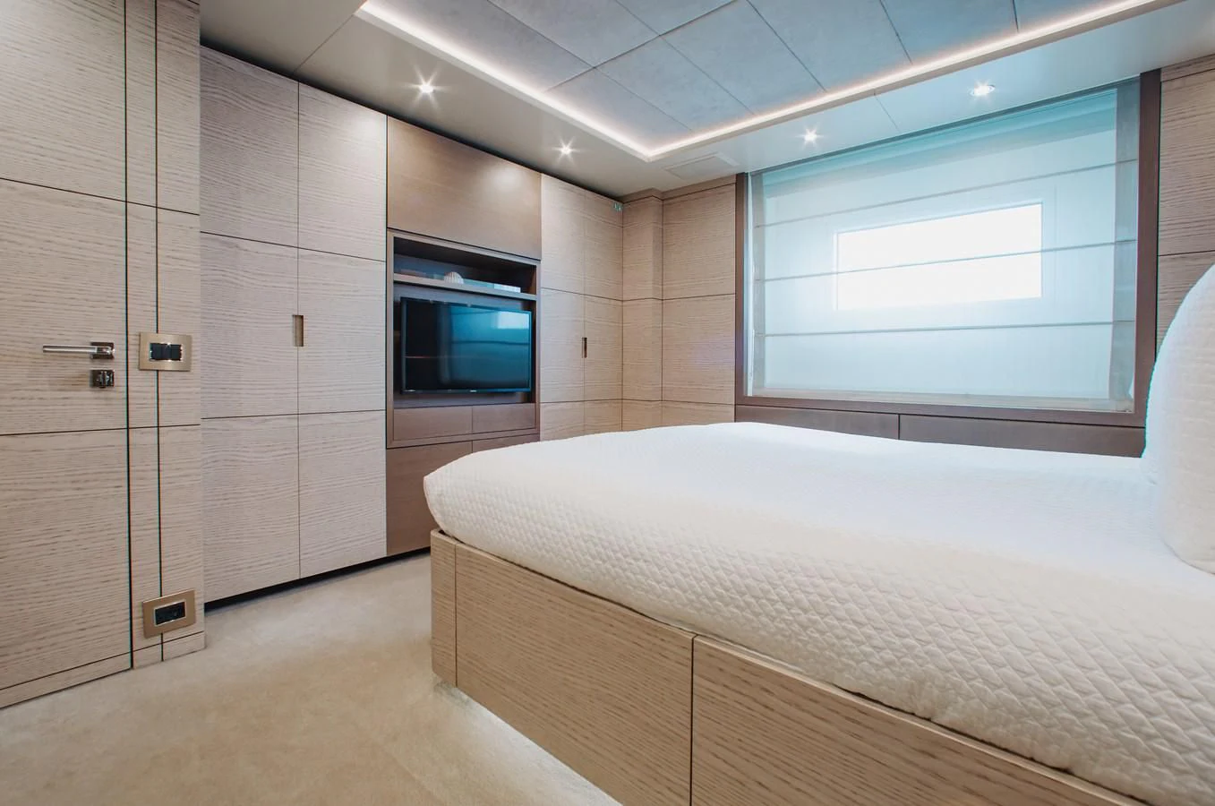 a bedroom with a bed and a window aboard COFINA Yacht for Sale