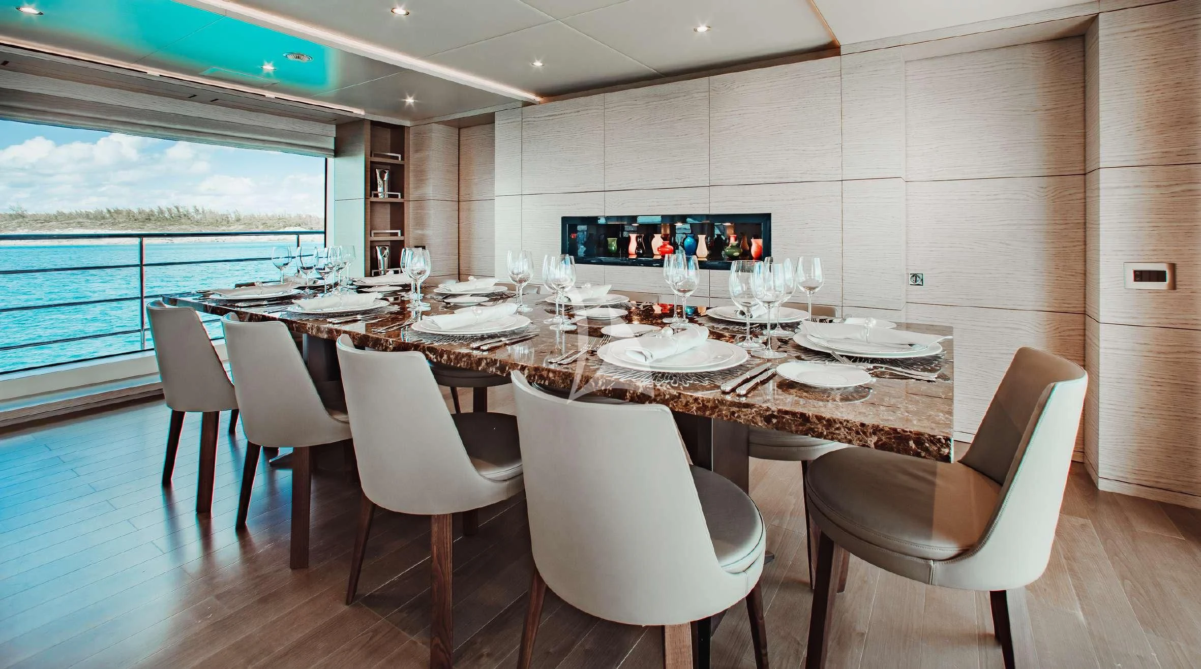 a large dining table with white chairs aboard COFINA Yacht for Sale