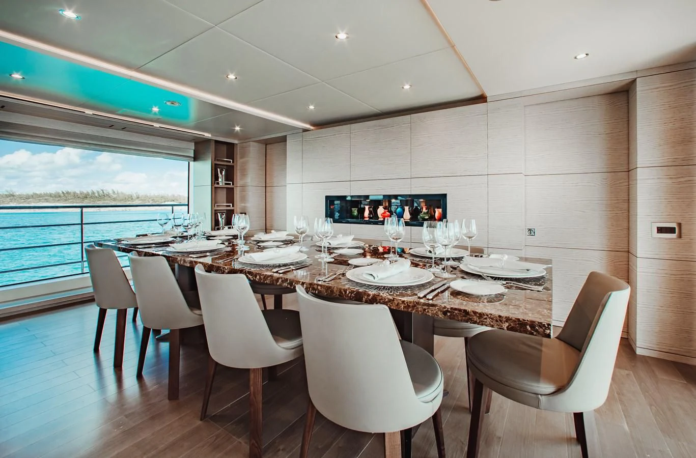 a large dining table with white chairs aboard COFINA Yacht for Sale