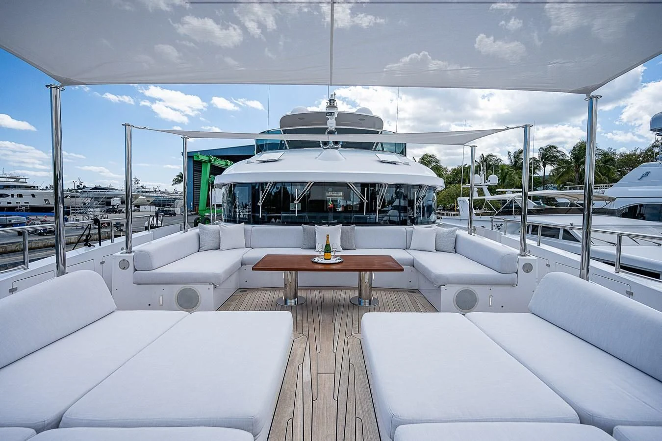 a large white lounge area with a table and chairs and a large white building with a white roof aboard COFINA Yacht for Sale