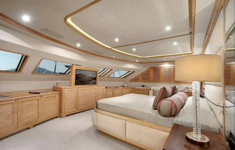 a room with a bed and a lamp aboard QUEST R Yacht for Sale