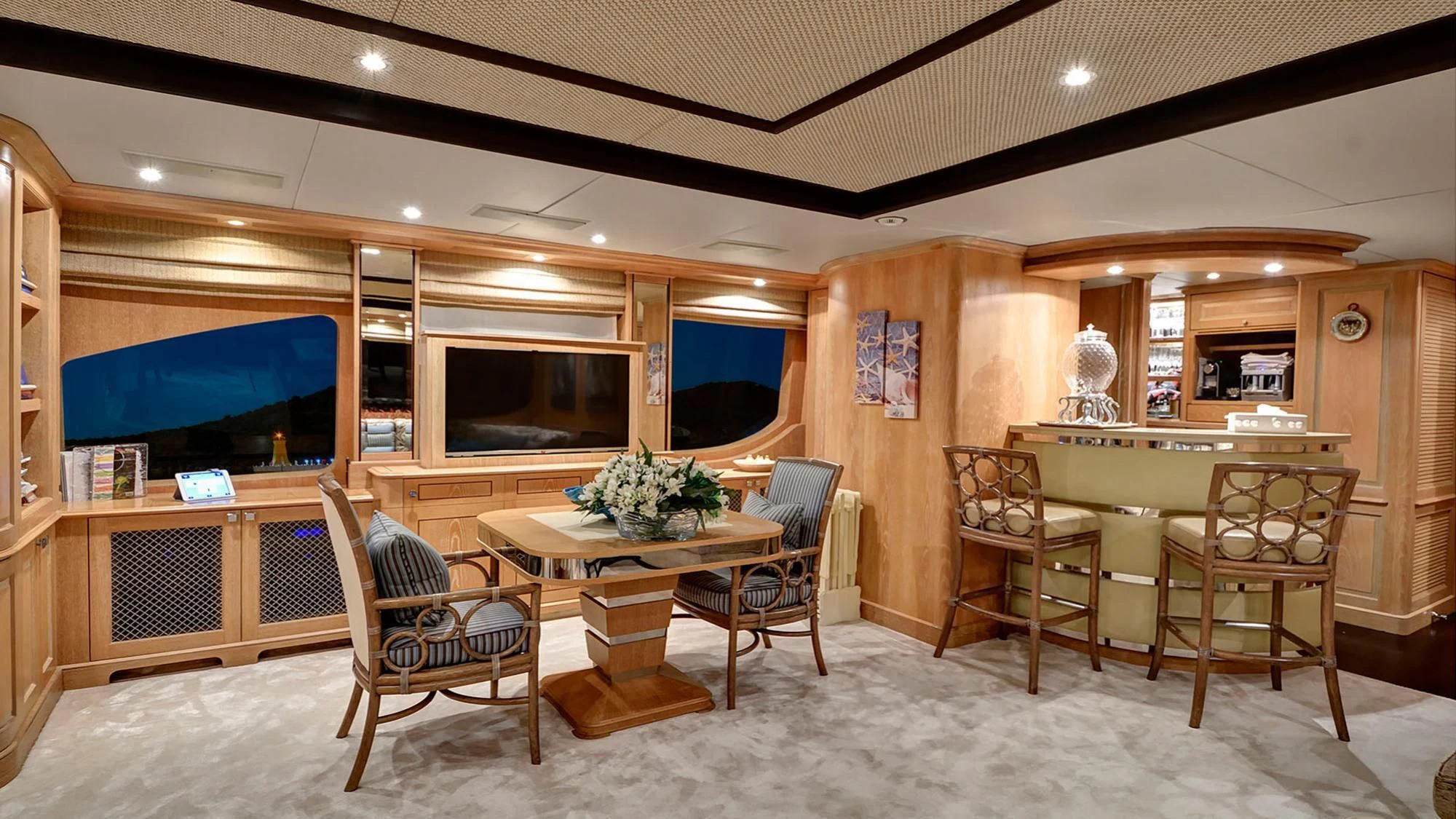 a room with a table chairs and a tv aboard QUEST R Yacht for Sale