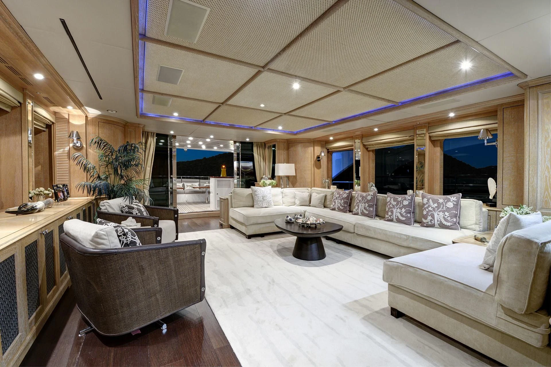 a large living room with a large white couch and a large window aboard QUEST R Yacht for Sale
