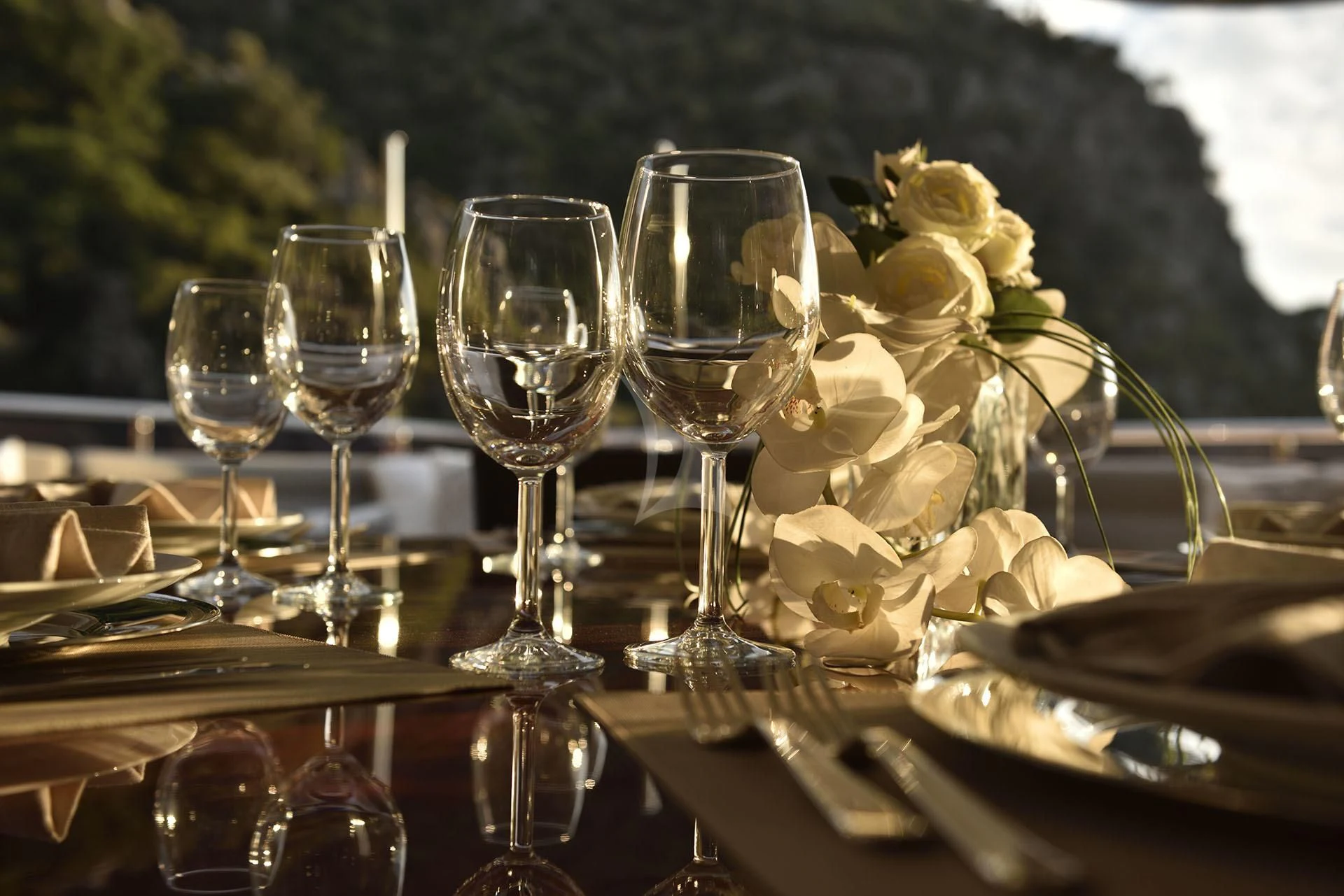 a table with wine glasses and flowers aboard QUEST R Yacht for Sale