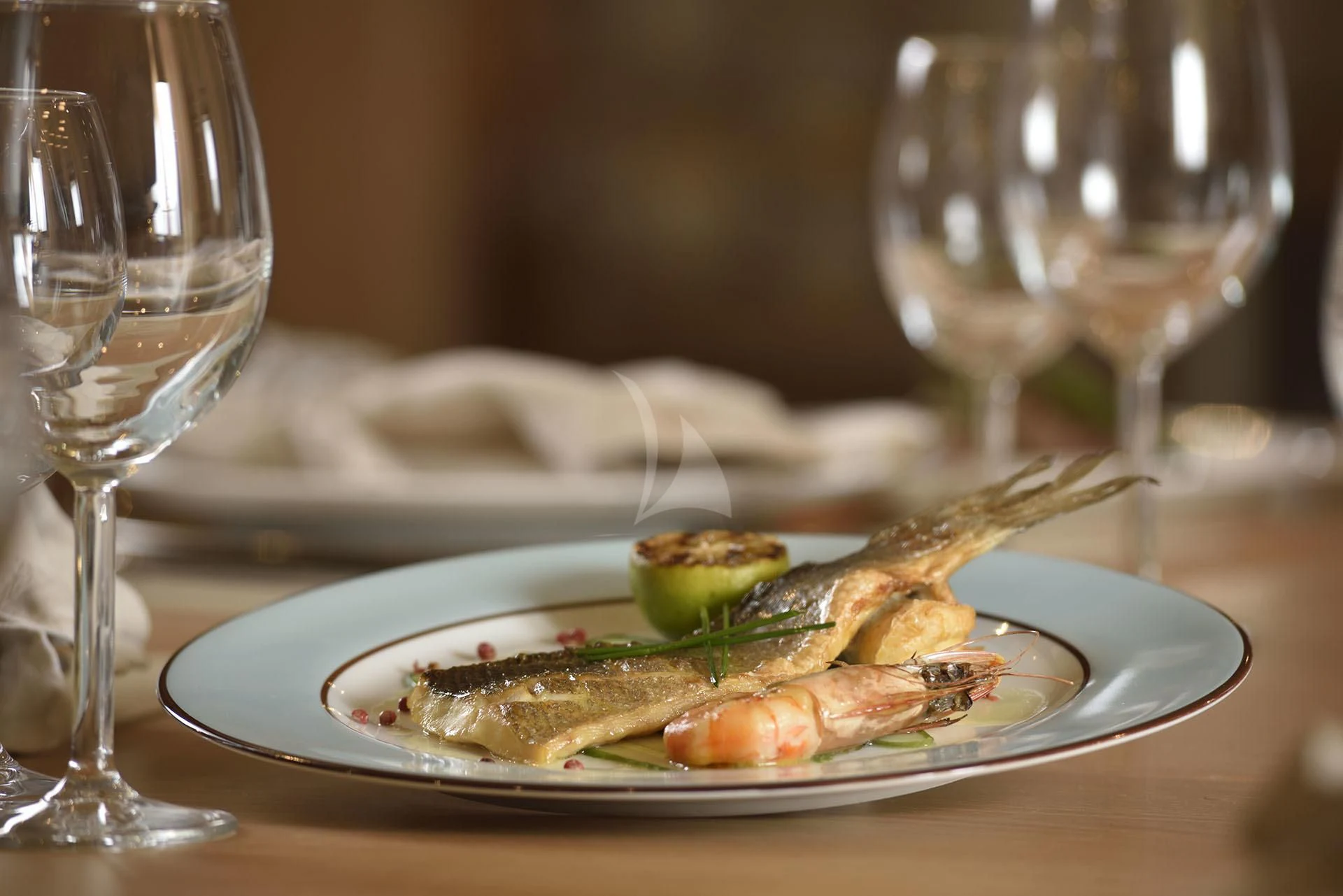 a plate of food and glasses aboard QUEST R Yacht for Sale