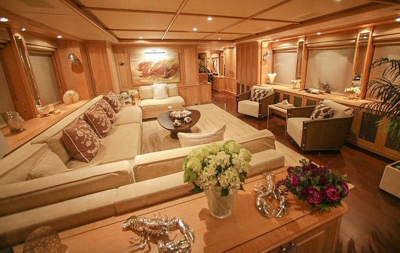 a large living room with a large couch and a table aboard QUEST R Yacht for Sale