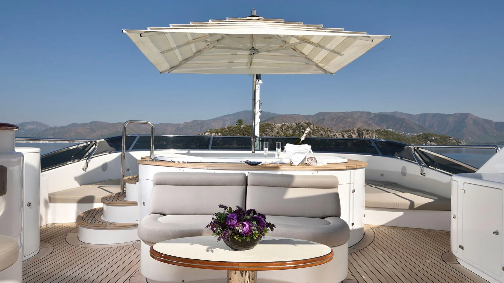 a white lounge chair on a deck overlooking a body of water aboard QUEST R Yacht for Sale