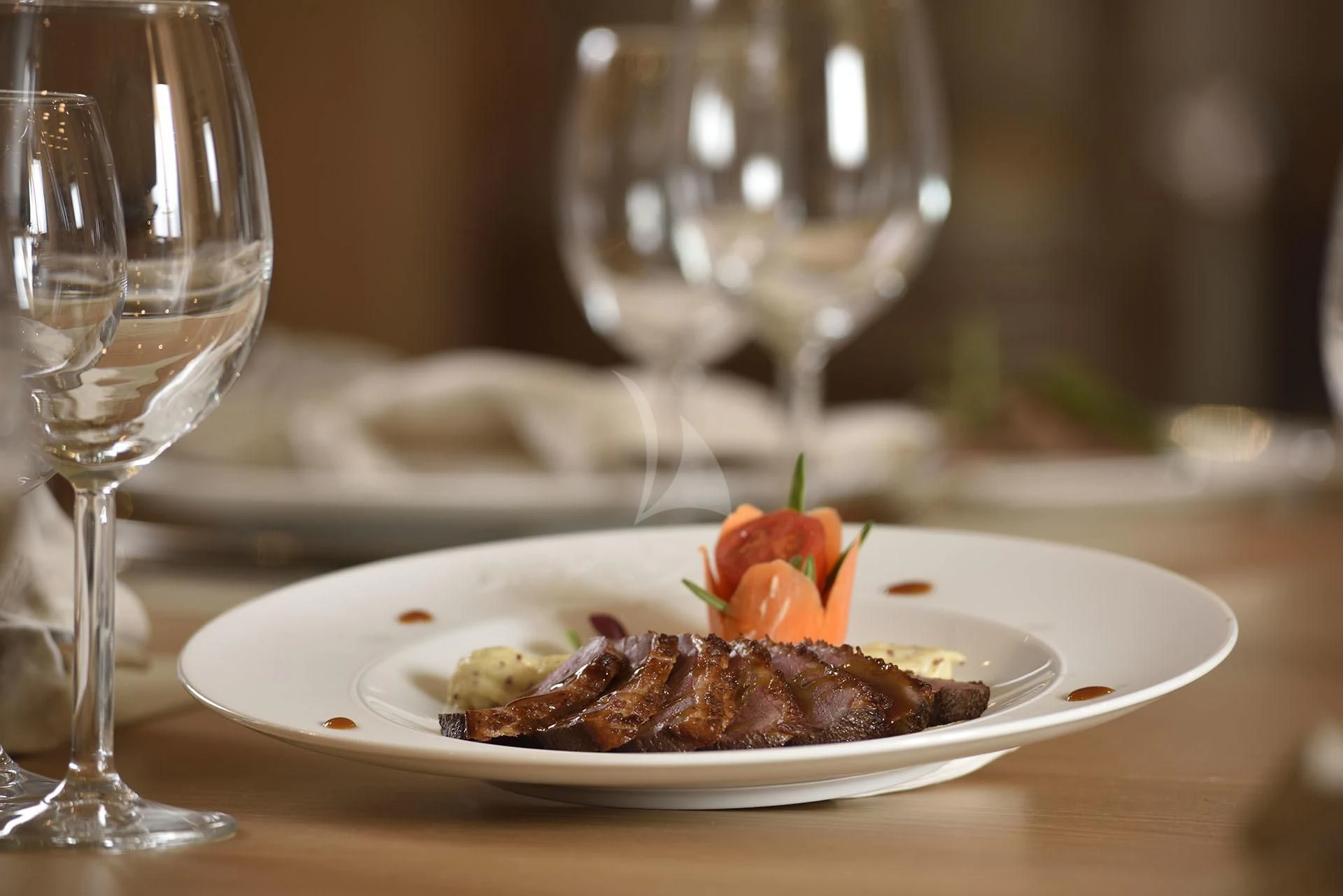 a plate of food and a glass of wine aboard QUEST R Yacht for Sale