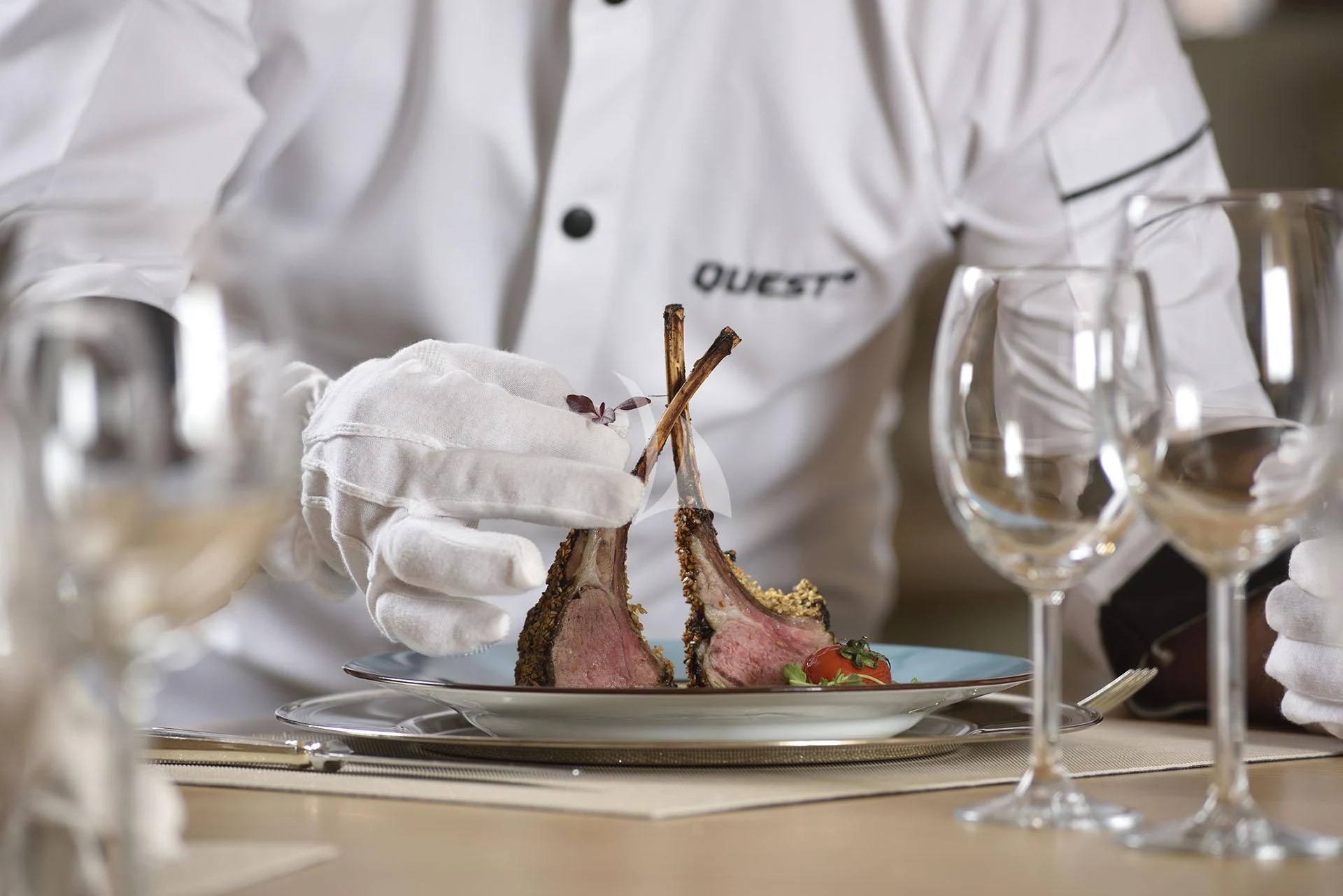 a person pouring wine into a glass aboard QUEST R Yacht for Sale