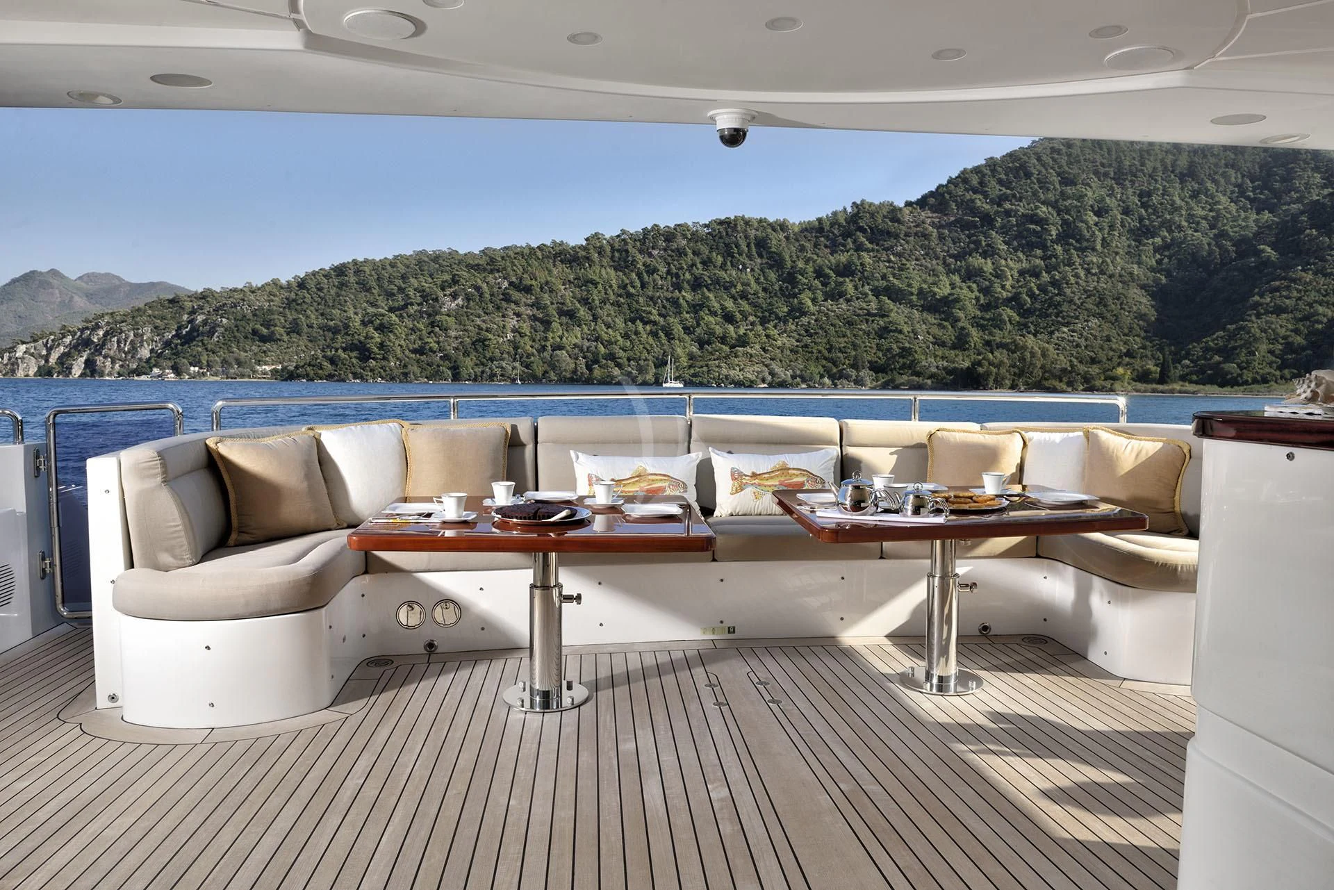a table and couches on a deck overlooking a large body of water aboard QUEST R Yacht for Sale
