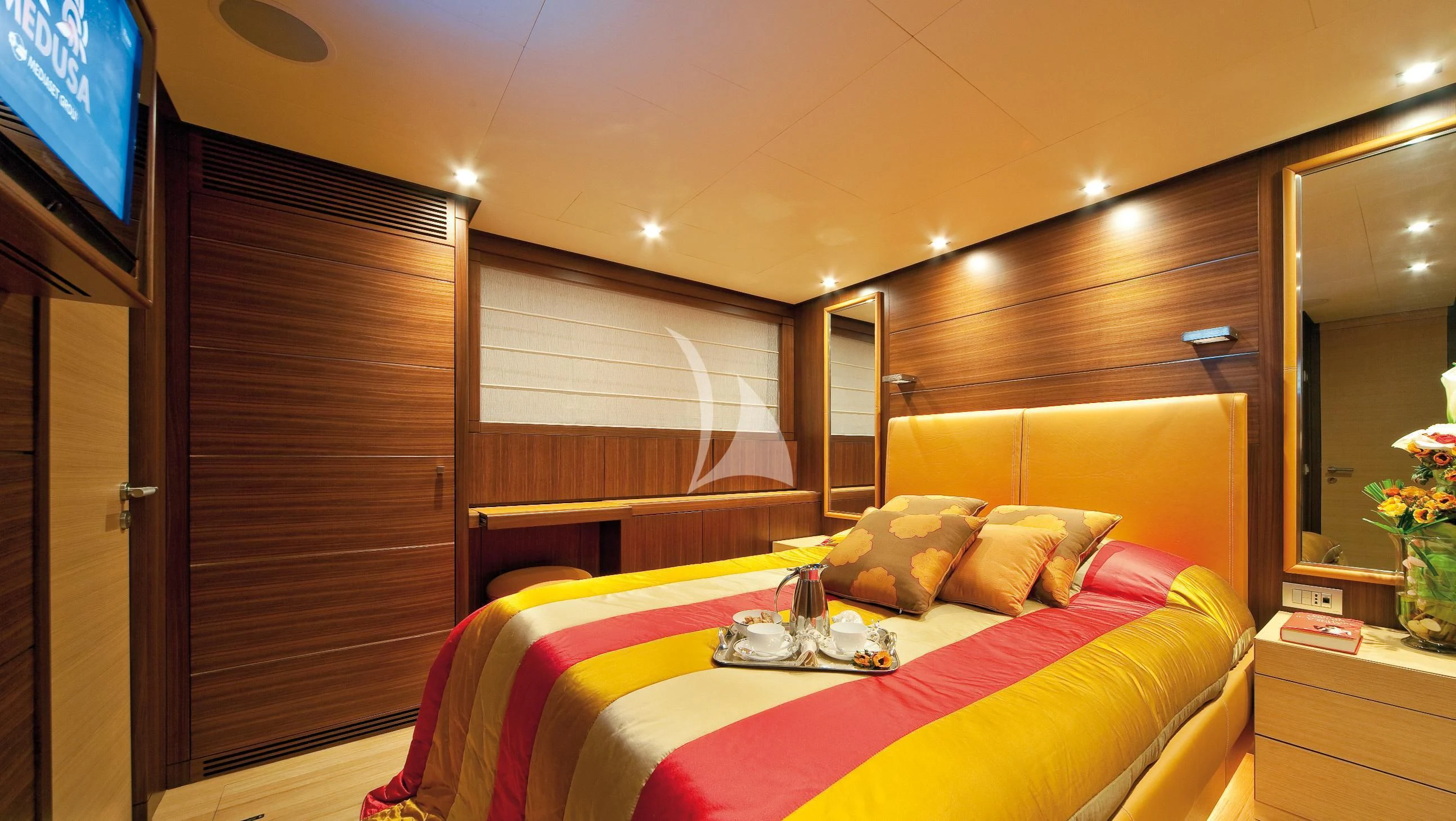 a bed with a colorful comforter aboard SOIREE Yacht for Sale