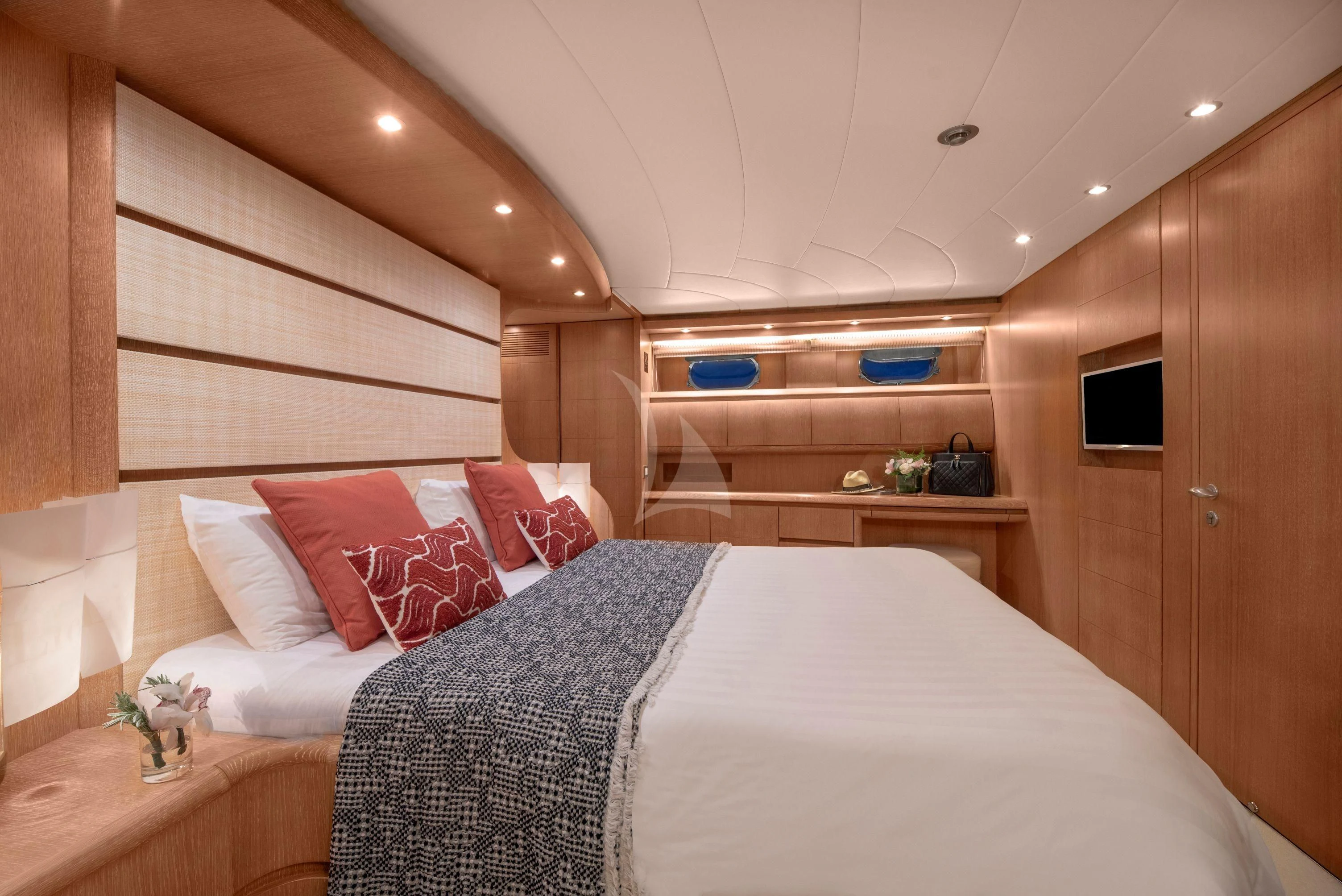 a bed with a white sheet and pillows in a room with wood cabinets aboard IRENE'S Yacht for Sale