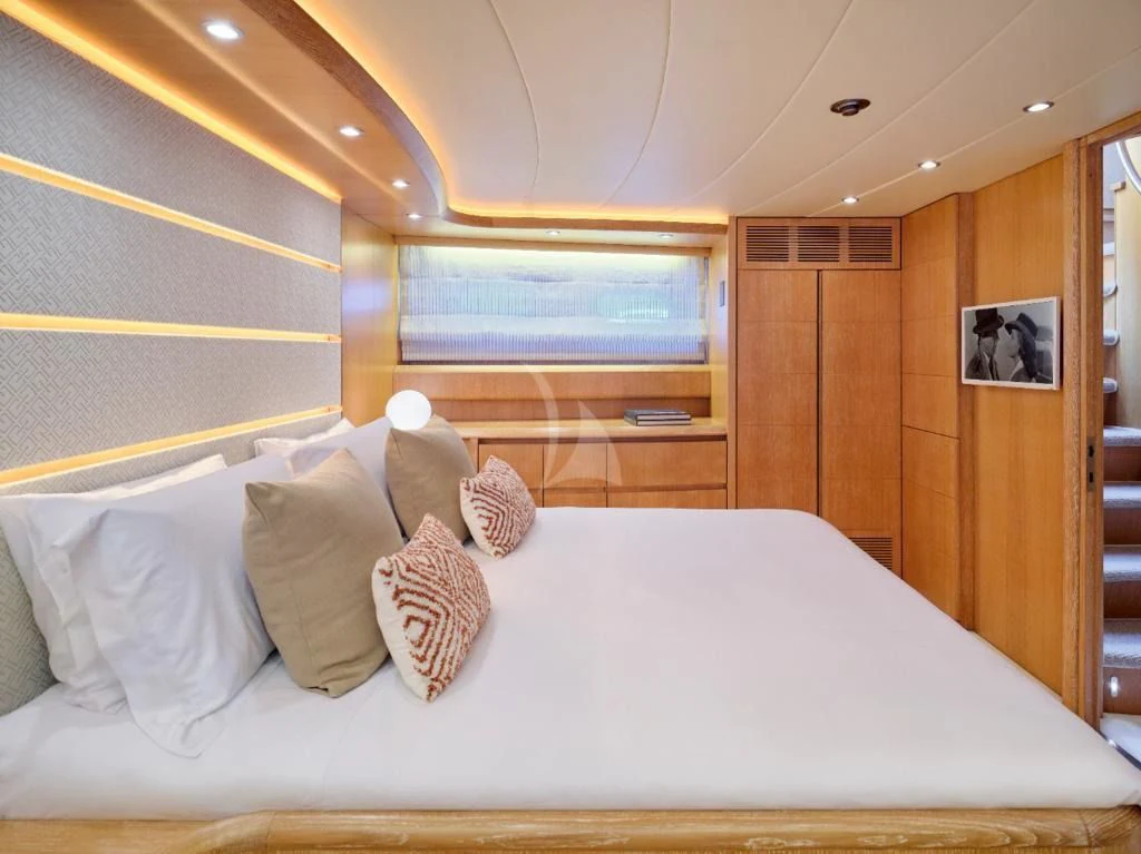 a bed with pillows and a television aboard IRENE'S Yacht for Sale