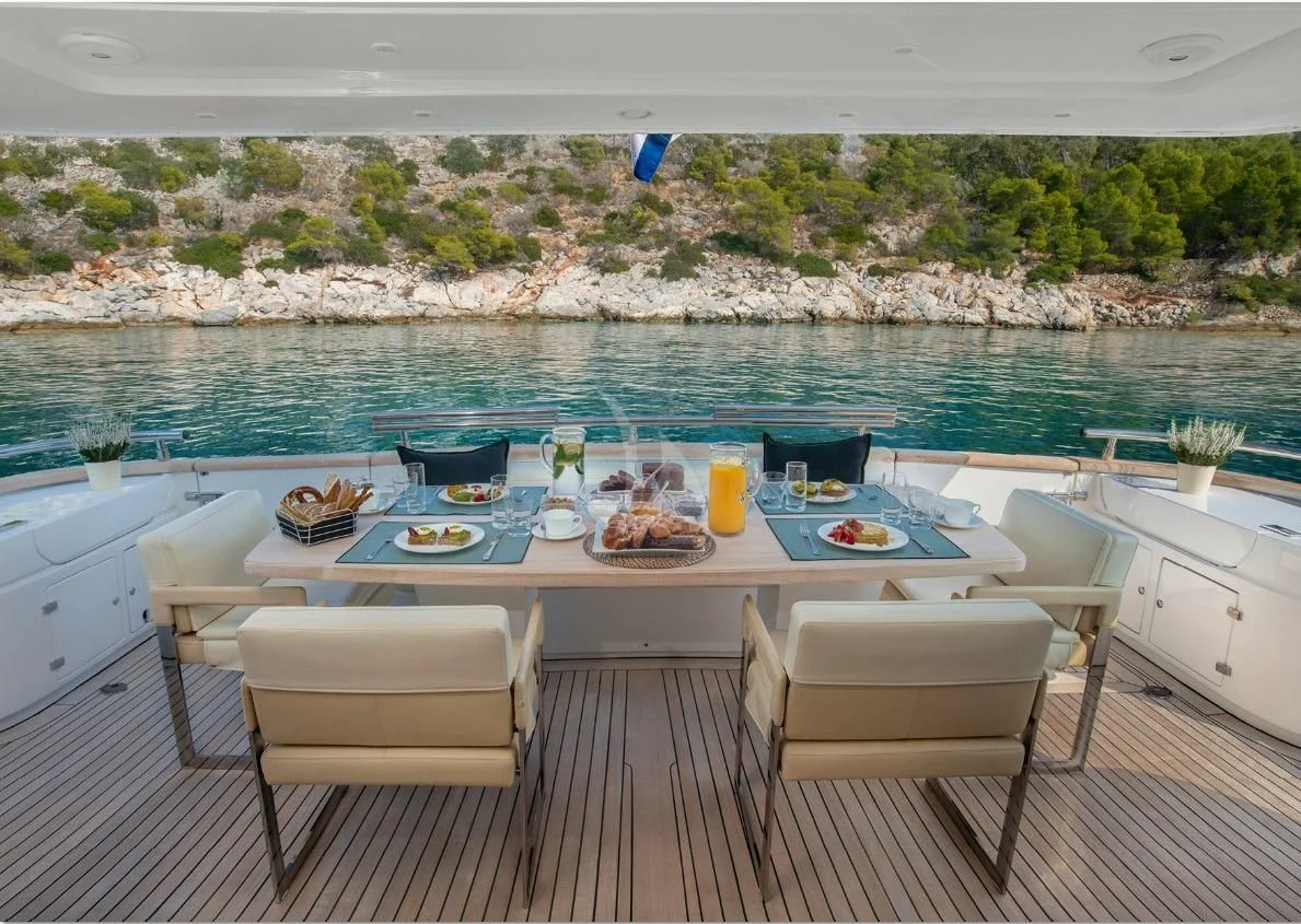 a table set for a meal on a deck overlooking a body of water aboard IRENE'S Yacht for Sale