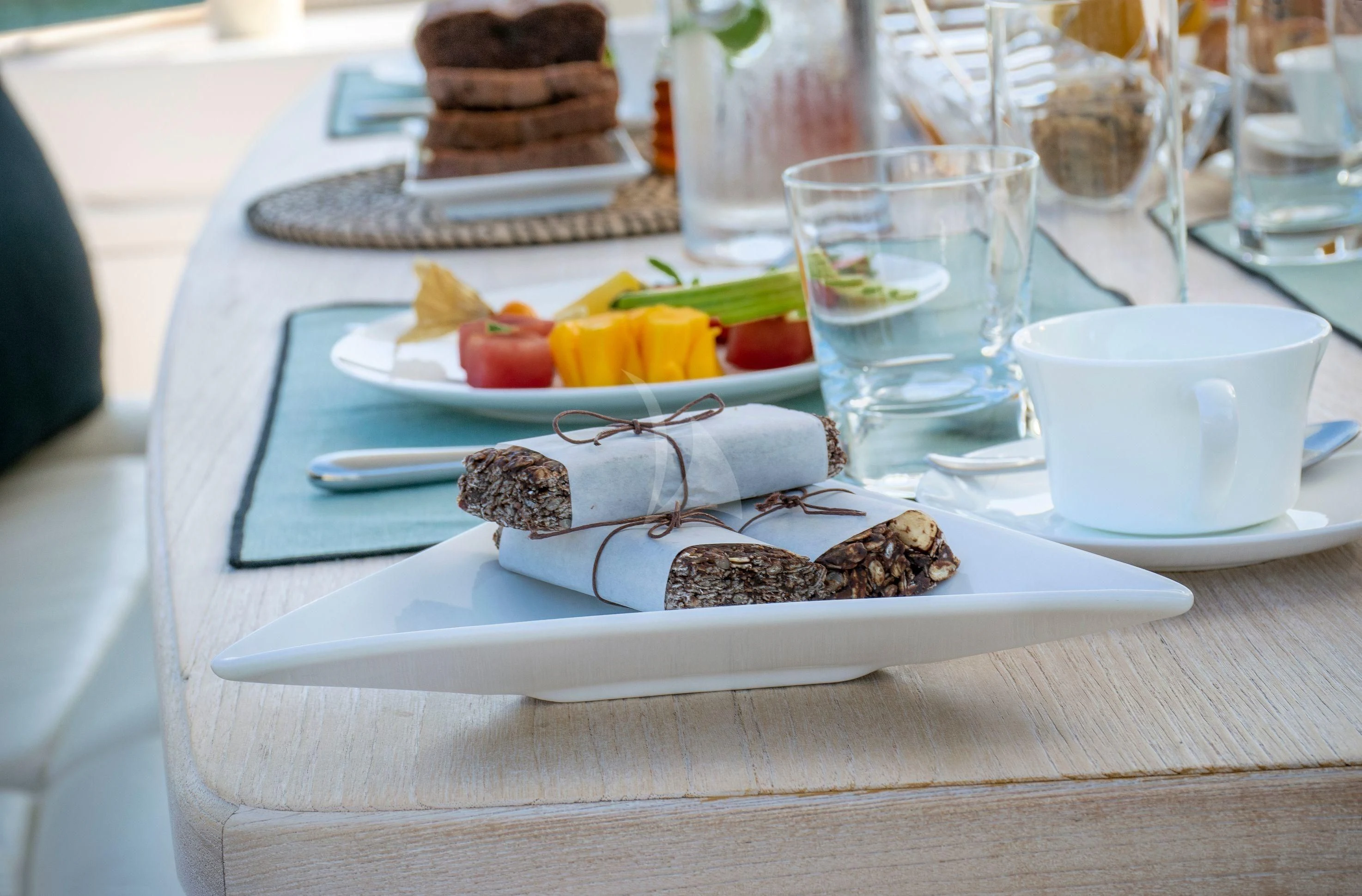 a table with a plate of food and a glass of water aboard IRENE'S Yacht for Sale