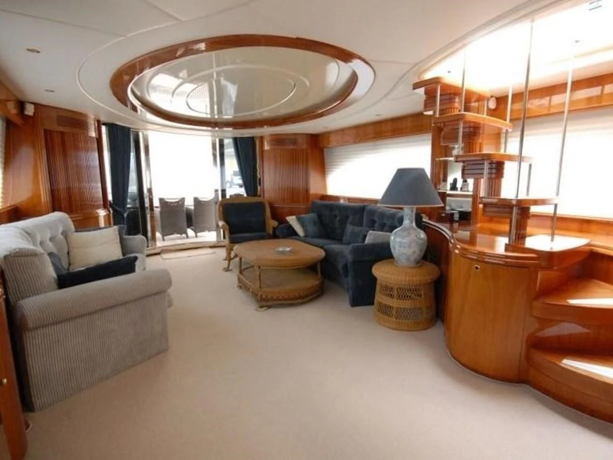 a living room with a large chandelier aboard STOLI Yacht for Sale