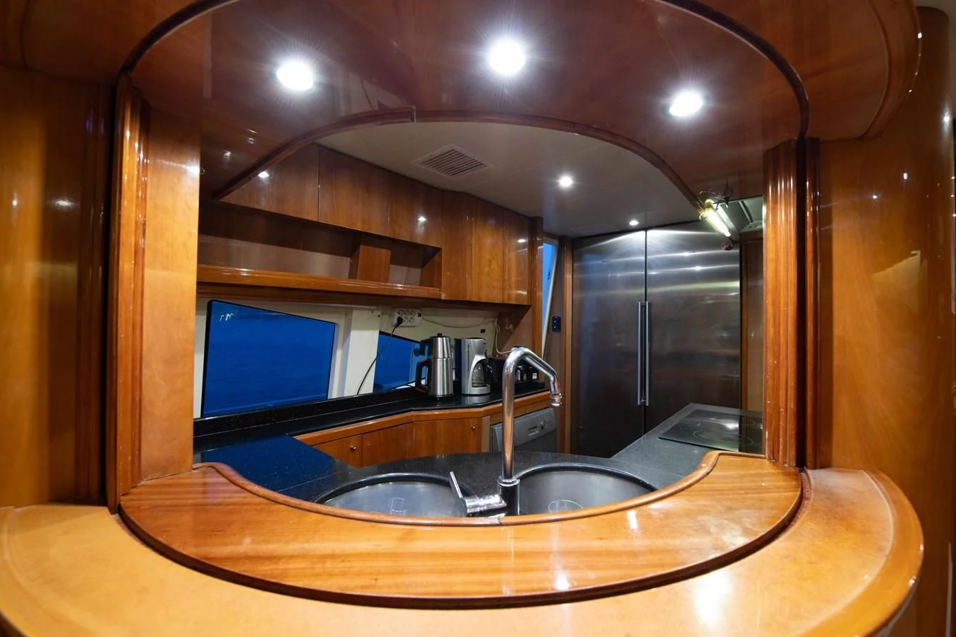 a kitchen with a sink and a large mirror aboard STOLI Yacht for Sale
