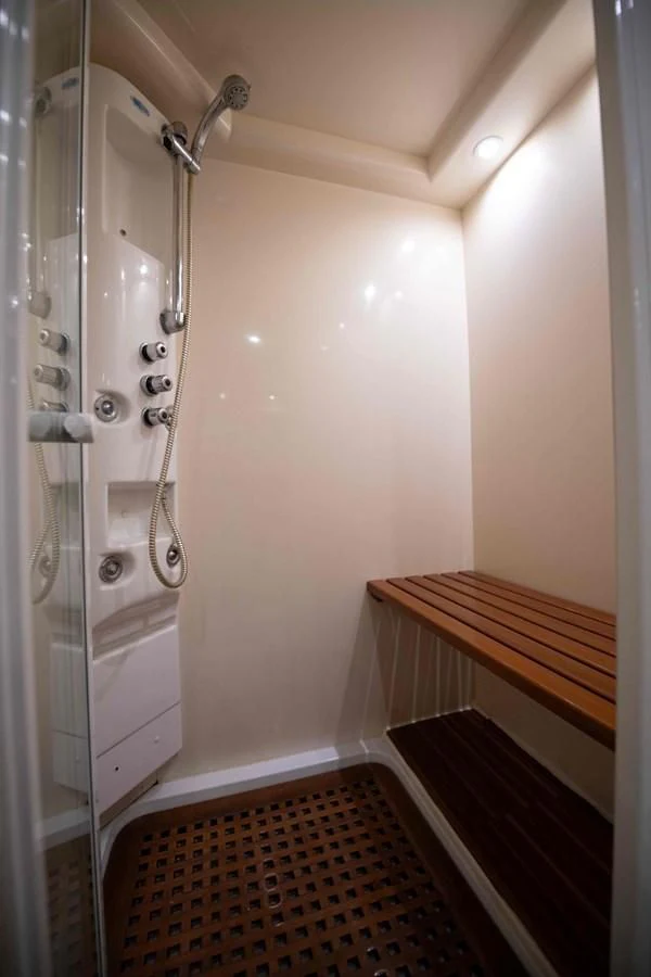 a shower with a red and white tiled floor aboard STOLI Yacht for Sale