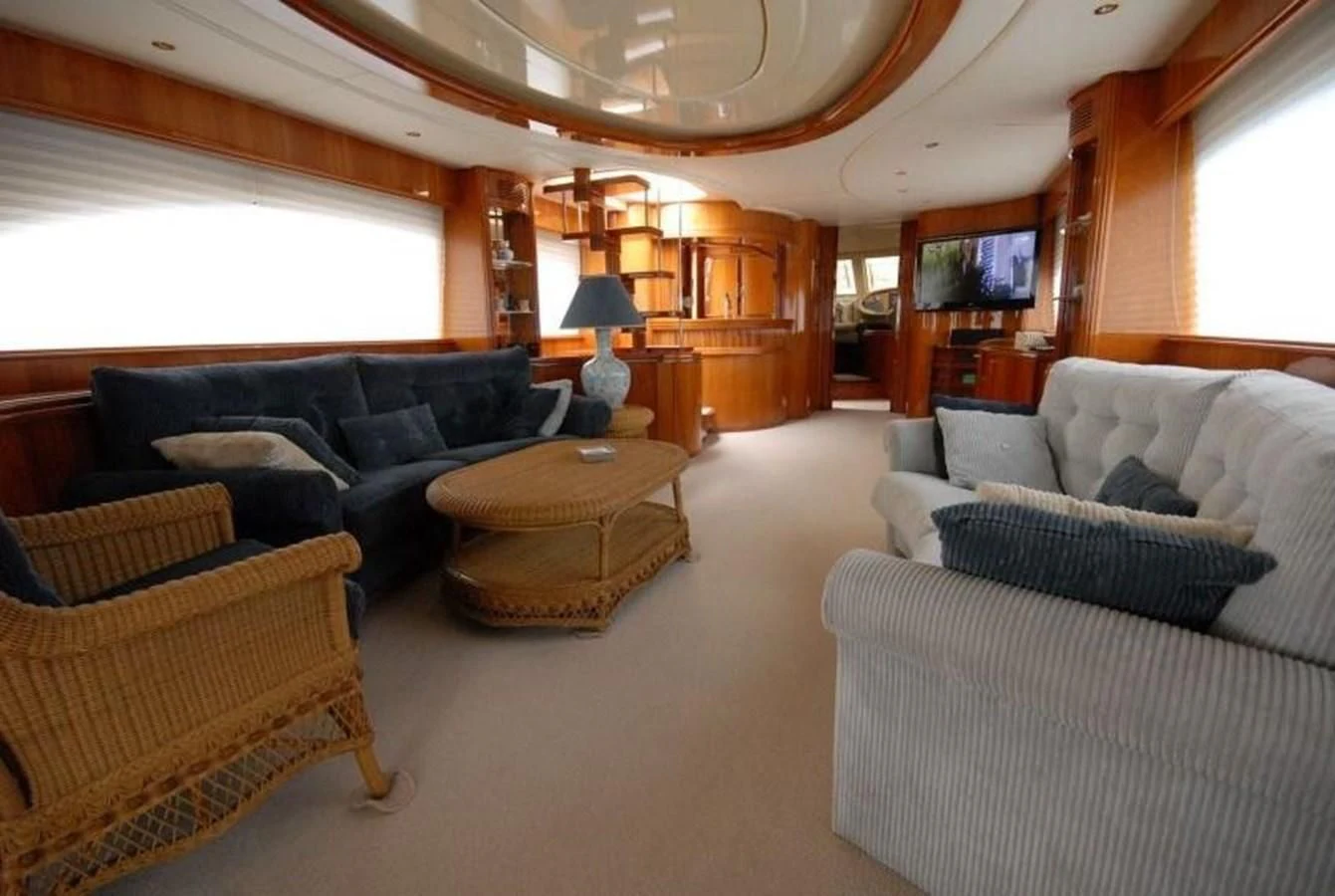 a living room with couches and a table aboard STOLI Yacht for Sale