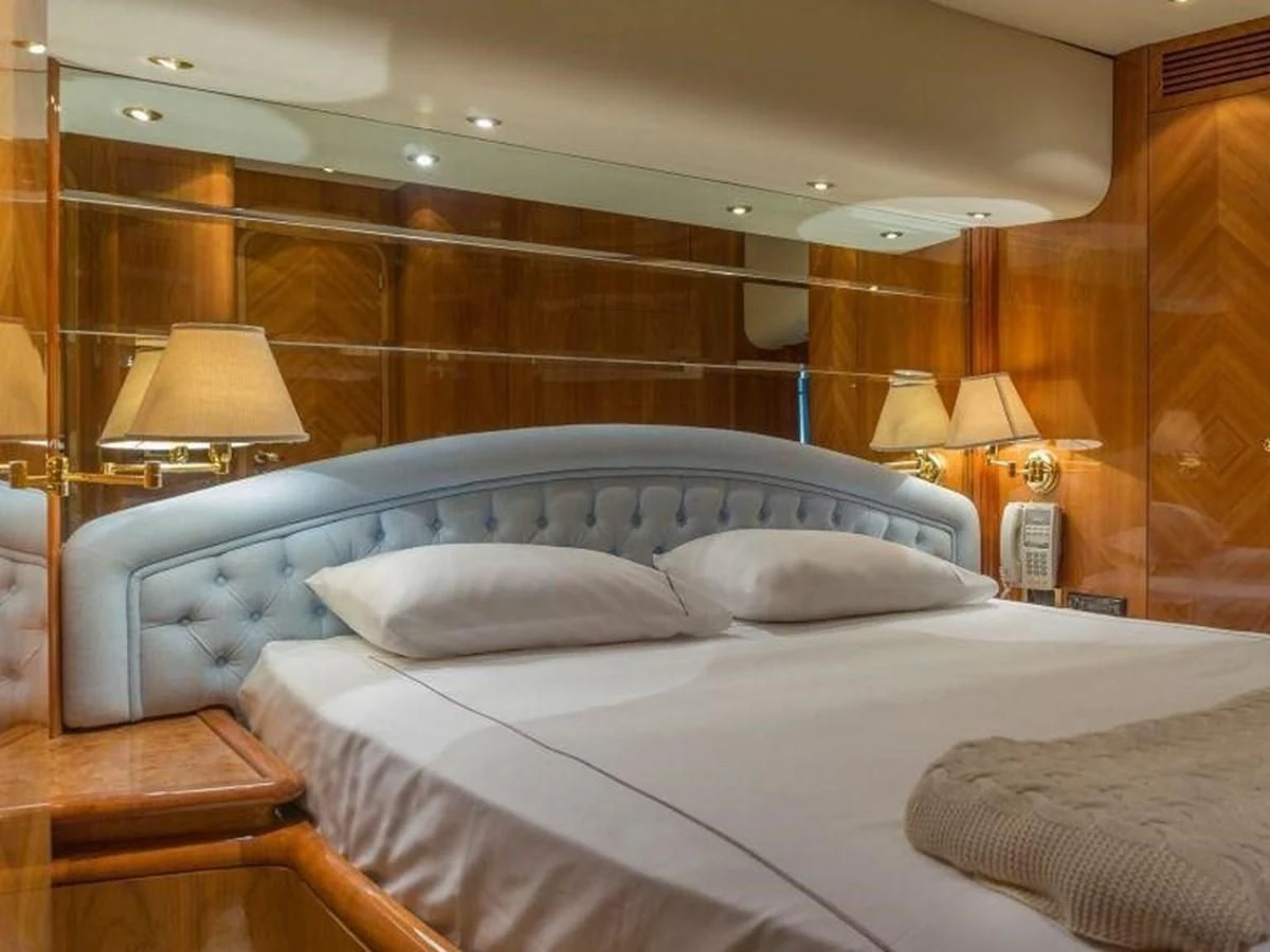 a bed with white sheets aboard STOLI Yacht for Sale