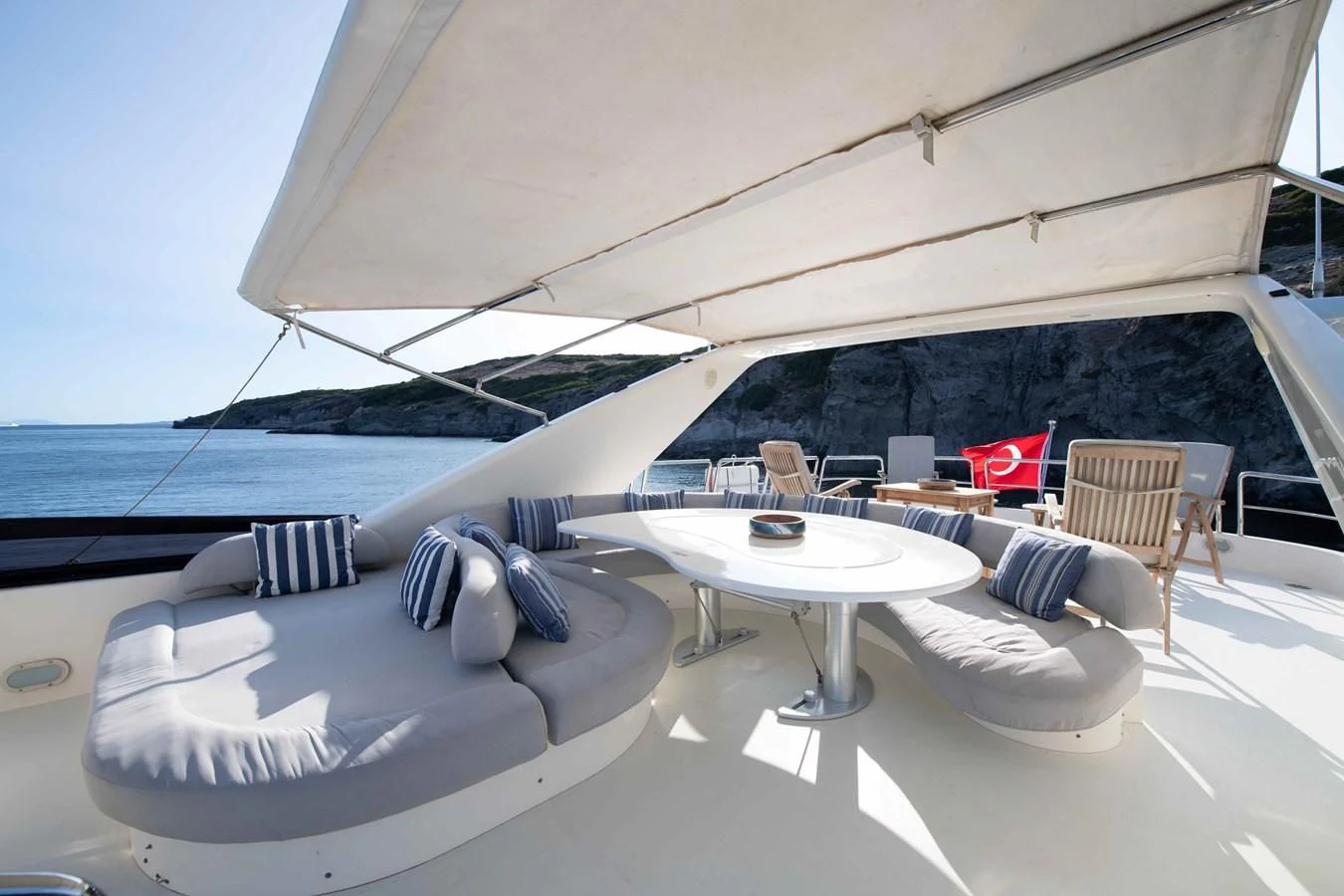 a lounge area with a table and chairs on it aboard STOLI Yacht for Sale